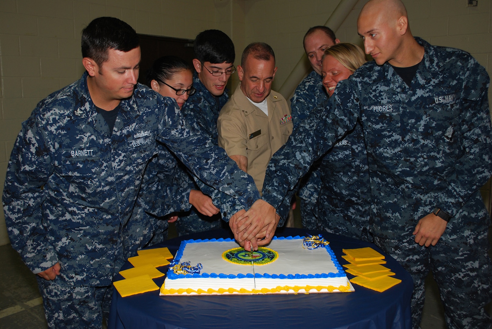 Rear Adm. William Roberts, commandant, Medical, Education and Training Campus, center, and fellow Sailors cut a cake during the June 25 ribbon-cutting ceremony officially opening the Wounded, Ill & Injured Annex at the Navy Operational Support Center, Joint Base San Antonio-Fort Sam Houston. The Annex will serve as an administrative liaison for Navy, Marine Corps and Coast Guard members receiving treatment through the San Antonio Military Medical Center at JBSH-FSH. Annex staff will also provide support to service members' families and a better means of communication, patient advocacy and navigation through complex medical issues while service members receive treatment. The Annex is a detachment of the Naval Health Clinic Corpus Christi.