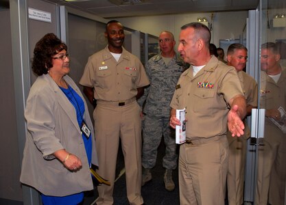 From center right, Rear Adm. William Roberts, commandant, Medical, Education and Training Campus; Capt. Adam Binford, commanding officer for the Navy Operational Support Center; Air Force Command Chief Master Sgt. Joel Berry, METC; Capt. James Bradley, commanding officer for the Naval Health Clinic Corpus Christi; and Suzanne Pedraza, lead case manager at the Wounded, Ill & Injured Annex, tour the spaces. The tour was part of a June 25 ribbon-cutting ceremony officially opening the Annex at the Navy Operational Support Center, Joint Base San Antonio-Fort Sam Houston. The Annex will serve as an administrative liaison for Navy, Marine Corps and Coast Guard members receiving treatment through the San Antonio Military Medical Center at JBSA-FSH. Annex staff will also provide support to service members' families and a better means of communication, patient advocacy and navigation through complex medical issues while service members receive treatment. The Annex is a detachment of the Naval Health Clinic Corpus Christi.