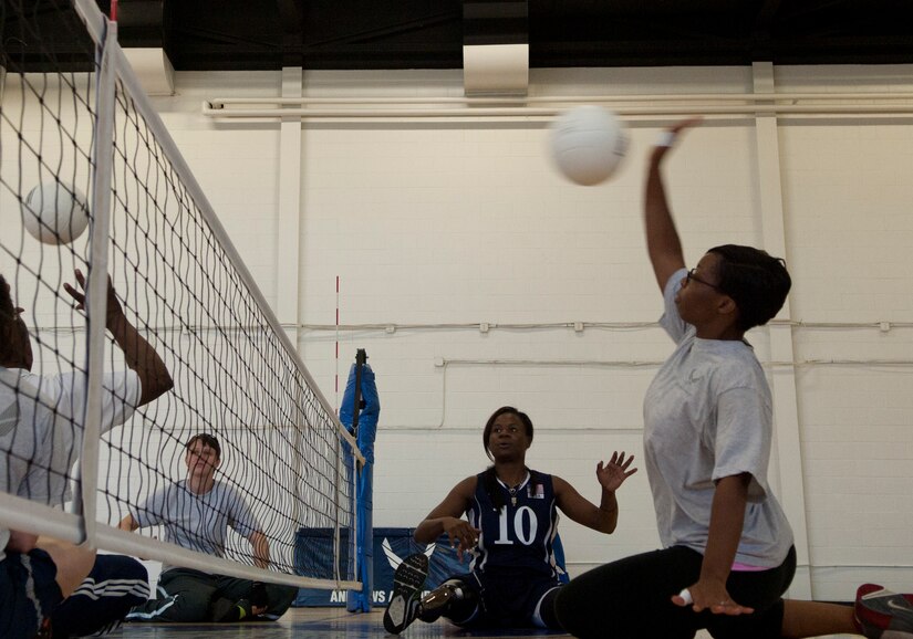 Kari Miller, U.S. Woman’s Sitting Volleyball Paralympic athlete and two-time silver medalist, teaches Air Force veteran Joshina Holmes, right, how to spike volleyball at an Air Force Wounded Warrior Sports Camp Clinic at the Joint Base Andrews West Fitness Center, Md., June 27, 2013.  The camp included sporting events such as wheelchair basketball, archery, swimming, air rifle/pistol shooting, and track and field. (U.S. Air Force photo/Airman 1st Class Nesha Humes)