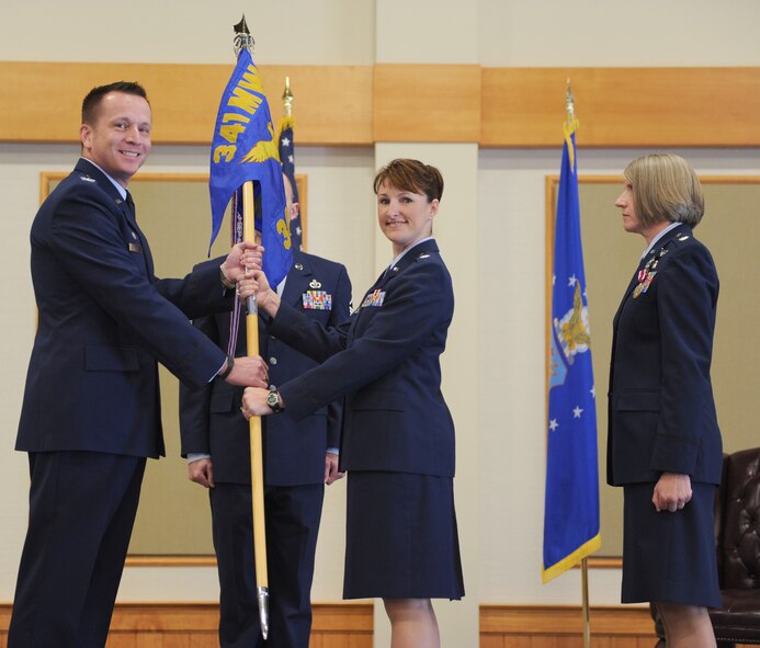 Lt. Col. Beatrice Dolihite, center, accepts command of the 341st Medical Operations Squadron from Col. R. Bruce Roehm, 341st Medical Group commander, at the Grizzly Bend on June 21. Lt. Col. Karee Jenson, the relinquishing commander of 341st MDOS, right, looks on. (U.S. Air Force photo/Senior Airman Katrina Heikkinen)