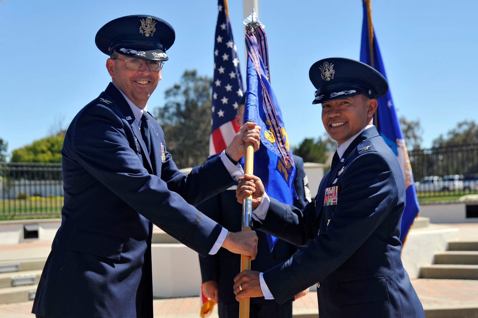 VANDENBERG AIR FORCE BASE, Calif. --  Col. Keith Balts, 30th Space Wing commander, passes the ceremonial guidon to Col. Marcelino Del Rosario, incoming 30th Operations Group commander, during a change of command here Tuesday, June 25. The passing of the guidon represents the transfer of authority and responsibility from one commander to the next. (U.S. Air Force photo/Michael Peterson)