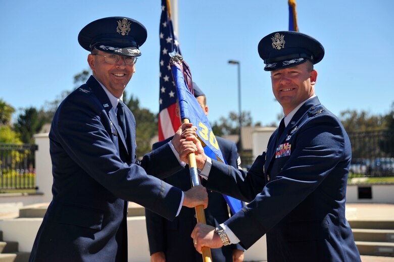 VANDENBERG AIR FORCE BASE, Calif. -- Col. Keith Balts, 30th Space Wing commander, accepts the ceremonial guidon from Col. David Hook, departing 30th Operations Group commander, during a change of command here Tuesday, June 25. The passing of the guidon represents the transfer of authority and responsibility from one commander to the next. (U.S. Air Force photo/Michael Peterson)