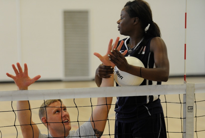 Kari Miller, U.S. Woman’s Sitting Volleyball Paralympic athlete and two-time silver medalist, teaches Senior Airman Michael Napier, 633rd Medical Dental Support Squadron patient member from Joint Base Langley-Eustis, Va. how to block at the Joint Base Andrews West Fitness Center, Md., June 27, 2013. Miller, a former Army veteran coached Air Force Wounded Warriors on the fundamentals of sitting volleyball.  (U.S. Air Force photo/Airman 1st Class Nesha Humes)