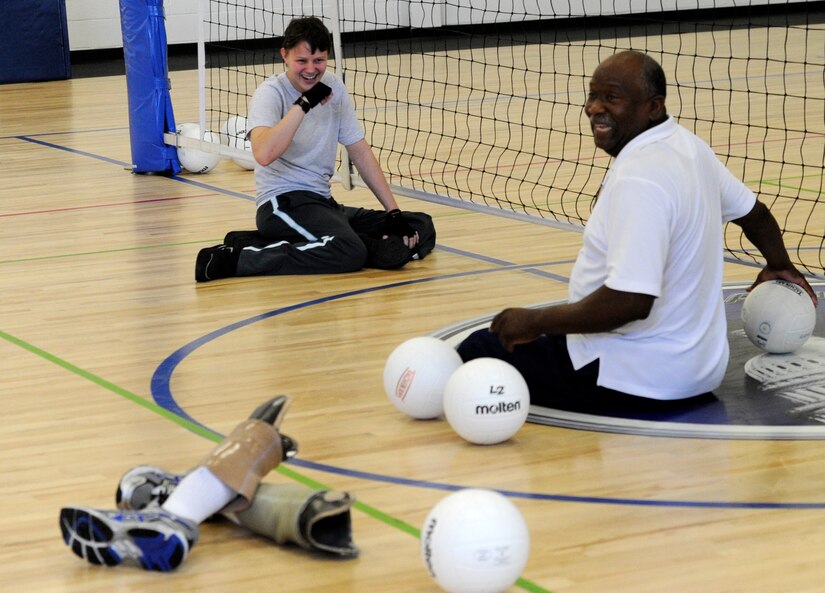 Airman 1st Class Haley Gilbraith, 315th Training Squadron imagery analyst from Goodfellow Air Force Base, Tx. laughs with coach during an Air Force Wounded Warrior Sports Camp sitting volleyball clinic at the Joint Base Andrews West Fitness Center, Md., June 27, 2013.  The camp included sporting events such as wheelchair basketball, archery, swimming, air rifle/pistol shooting, and track and field. (U.S. Air Force photo/Airman 1st Class Nesha Humes)