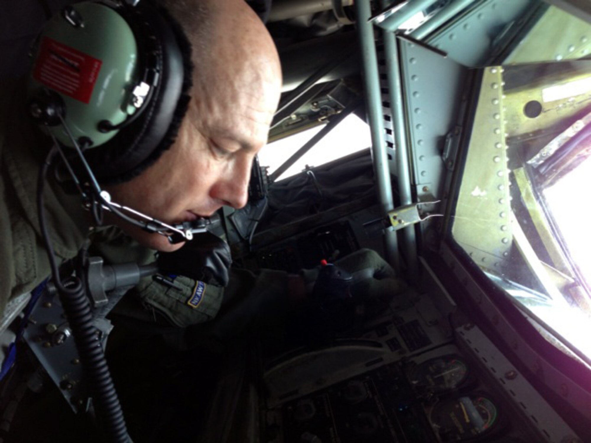 Senior Master Sgt. Ray Lewis, a refueling boom operator assigned to the Air Force Reserve 18th Air Refueling Squadron, 931st Air Refueling Group, McConnell Air Force Base, Kan., peers out of the boom pod of a KC-135 Stratotanker during an air refueling training mission June 27, 2013.  The KC-135 was refueling a B-52 Stratofortress assigned to the 5th Bomb Wing, Minot Air Force Base, N.D.  Air refueling training missions ensure that both the refueling and receiving aicrews maintain proficiency in air refueling operations, which allows the U.S. Air Force to extend its reach around the globe.  (U.S. Air Force photo by Senior Airman Sierra Dopfel)