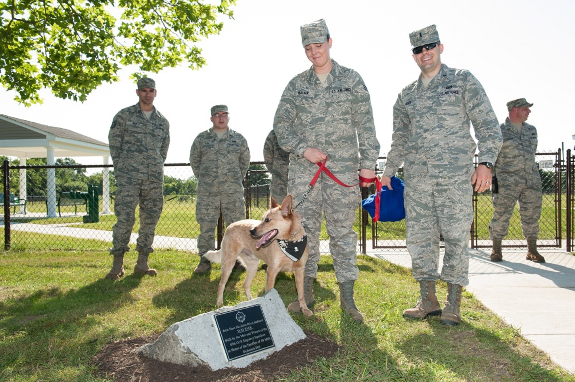 Senior Airman Brianna Walker, 87th Civil Engineer Squadron operations manager, Walker’s dog, Roo, and 1st Lt. Kenneth Hynes, 87th CES operations support chief, attend the dedication of the new dog park June 25, 2013, at Joint Base McGuire-Dix-Lakehurst, N.J. The park, which 87th CES members built, has an obstacle course, water fountains, gazebos and fenced in areas for dogs to play. The construction helped the 87th CES members practice procedures for their deployed mission and also provide the base community recreation venue. (U.S. Air Force photo by Russ Meseroll/Released)