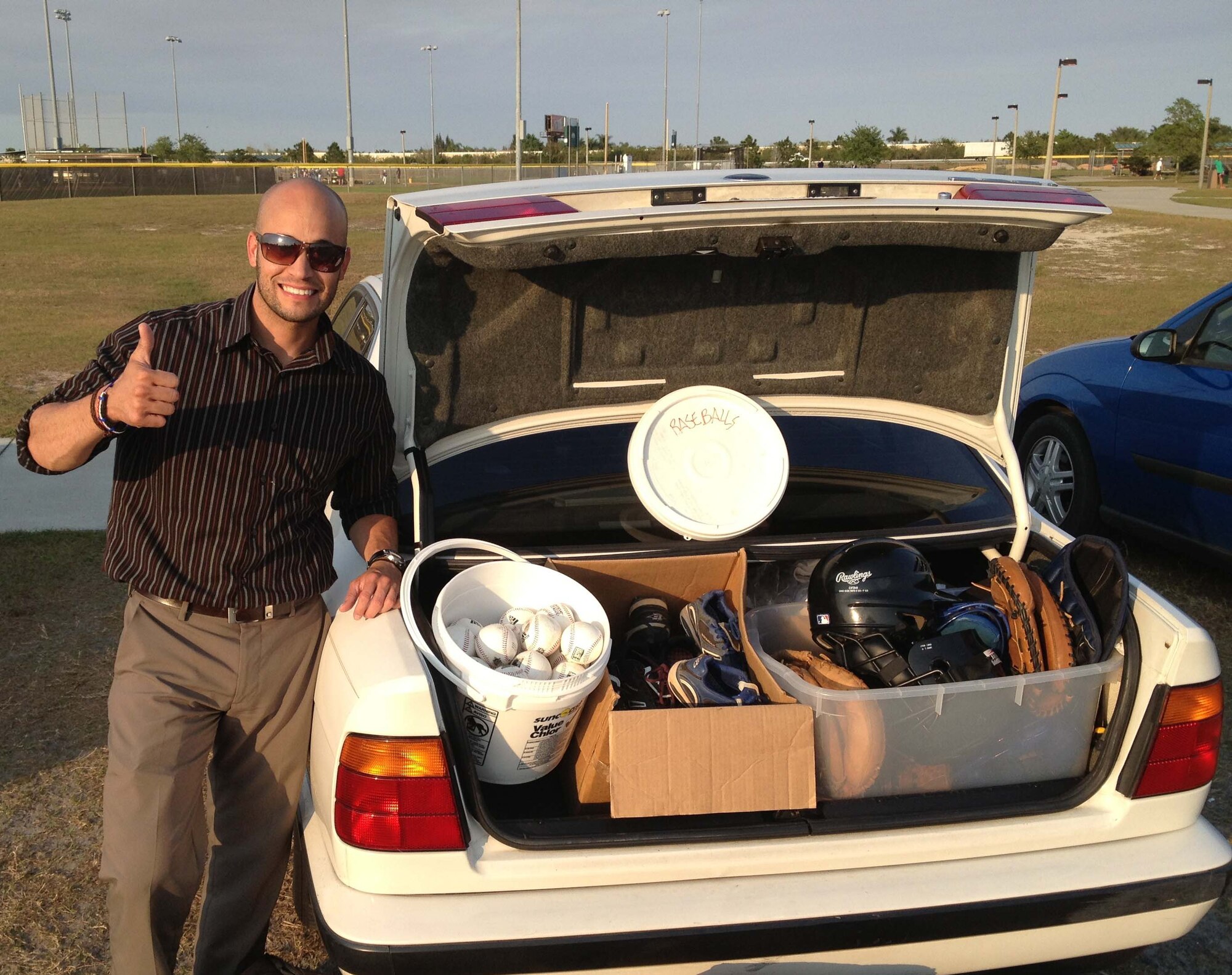 Rafael Nuñez Jr., gives a thumbs up after collecting several pieces of used baseball equipment to distribute to underprivileged youth in the Dominican Republic. Nuñez, a computer security manager with the Air Force Technical Applications Center at Patrick AFB, Fla., founded a non-profit organization called ‘Giving Feels Awesome,’ whose charter is to “embrace opportunities to connect givers at every level to underprivileged children in need of a lift, hope and happiness through sports participation.”  (Courtesy Photo)

