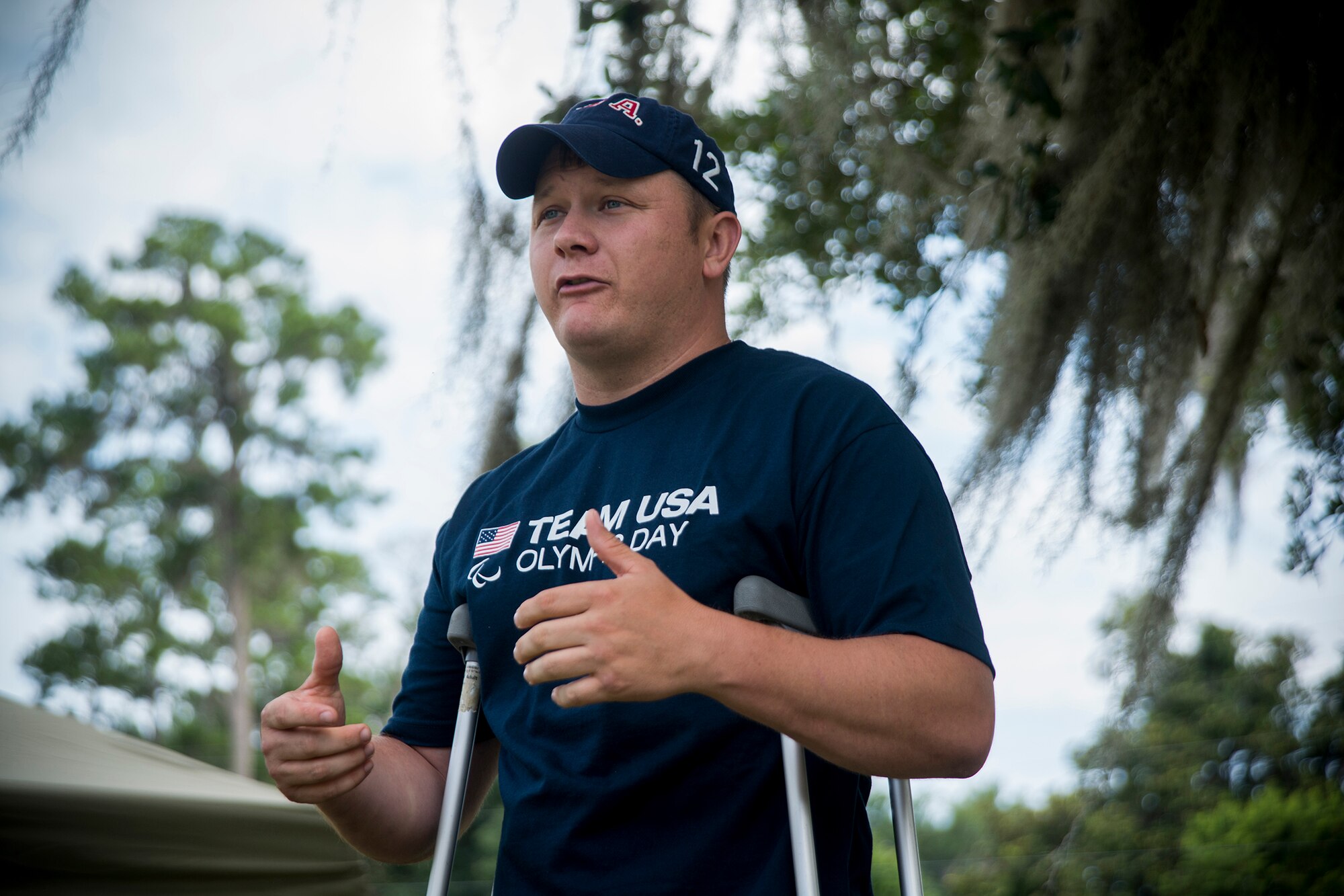 U.S. Army Sgt. 1st Class Joshua Olson, Army Marksmanship Unit international rifle shooter out of Fort Benning, Ga., gives remarks to kick off Olympic Day at Moody Air Force Base, Ga., June 21, 2013. Olson is the first active-duty Soldier to ever compete in the Paralympics and visited Moody to share his Olympic spirit with children. (U.S. Air Force photo by Staff Sgt. Jamal D. Sutter/Released)