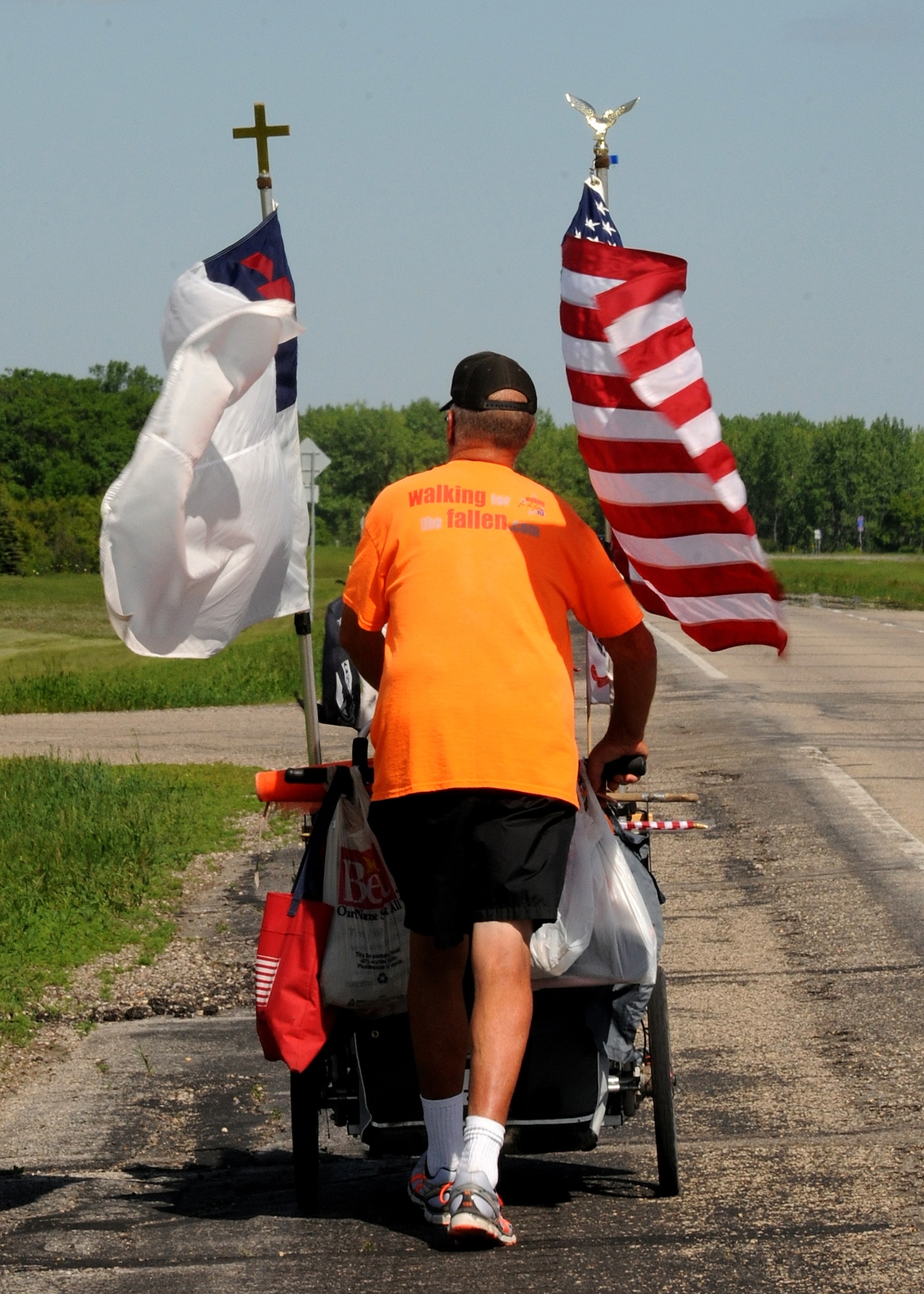 Walking cross-country to raise $50,000 for wounded and disabled veteran programs, military veteran Sgt. Chuck Lewis travels near Grand Forks Air Force Base, N.D. on June 13, 2013.  Lewis carries everything he needs on his cart necessary to set up camp where available along the way to the Vietnam Veterans Memorial wall in Washington, D.C. (U.S. Air Force photo/Airman 1st Class Ashley Nicole Taylor)