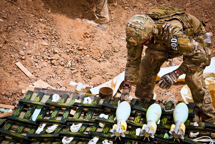 U.S. Air Force Staff Sgt. Lyle Flagg, 466th Air Expeditionary Squadron Explosive Ordnance Disposal technician and Livermore Falls, Maine, native, places excess military ordnance in preparation for a controlled detonation outside of Kandahar Airfield, Afghanistan June 12, 2013. U.S. Air Force, U.S. Army, Slovakian and Australian EOD personnel participated in a joint mission to dispose of excess military ordnance. Flagg is deployed from Nellis Air Force Base, Nev. (U.S. Air Force photo/Senior Airman Scott Saldukas)