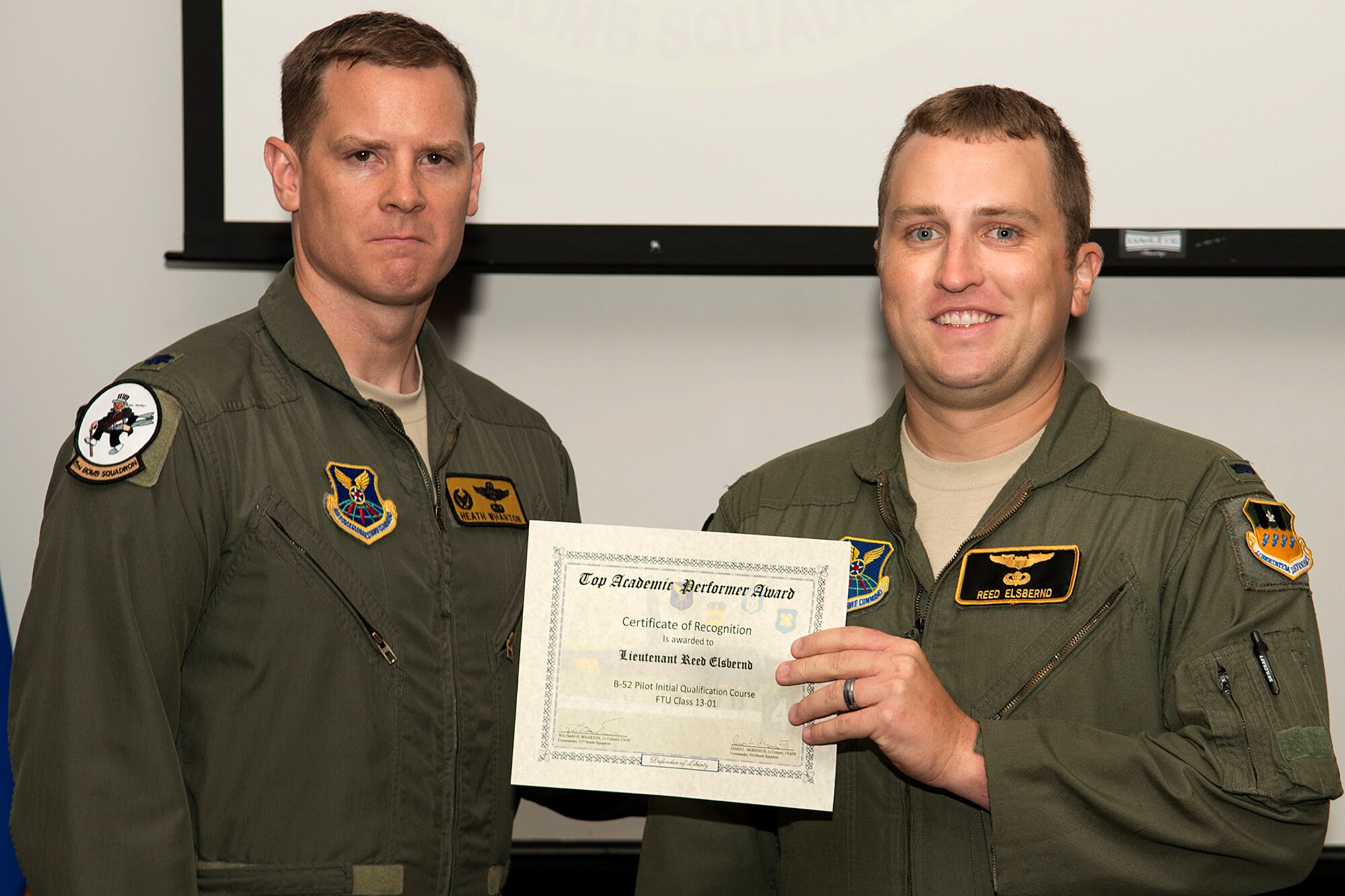 U.S. Air Force Lt. Col. William Wharton, 11th Bomb Squadron commander, presents the Copilot Outstanding Academic Performer certificate to 1st Lt. Reed Elsbernd, during a Formal Training Unit graduation ceremony, June 14, 2013, Barksdale Air Force Base, La. Elsbernd achieved an overall academic average of 99.64 percent. (U.S. Air Force photo by Master Sgt. Greg Steele/Released)