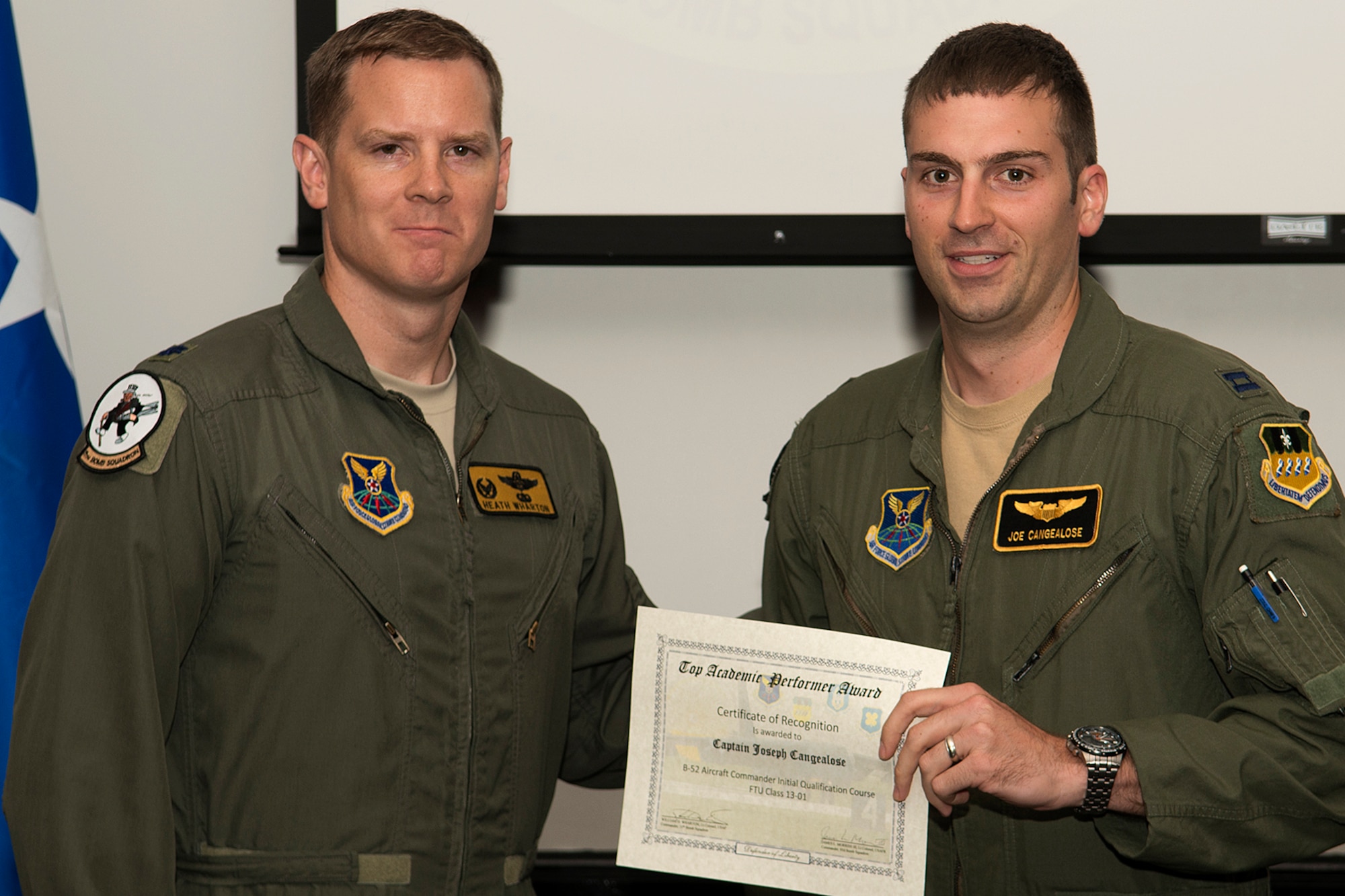 U.S. Air Force Lt. Col. William Wharton, 11th Bomb Squadron commander, presents the Aircraft Commander Outstanding Academic Performer certificate to Capt. Joseph Cangealose, during a Formal Training Unit graduation ceremony, June 14, 2013, Barksdale Air Force Base, La. Cangealose achieved an overall academic average of 99.29 percent. (U.S. Air Force photo by Master Sgt. Greg Steele/Released)