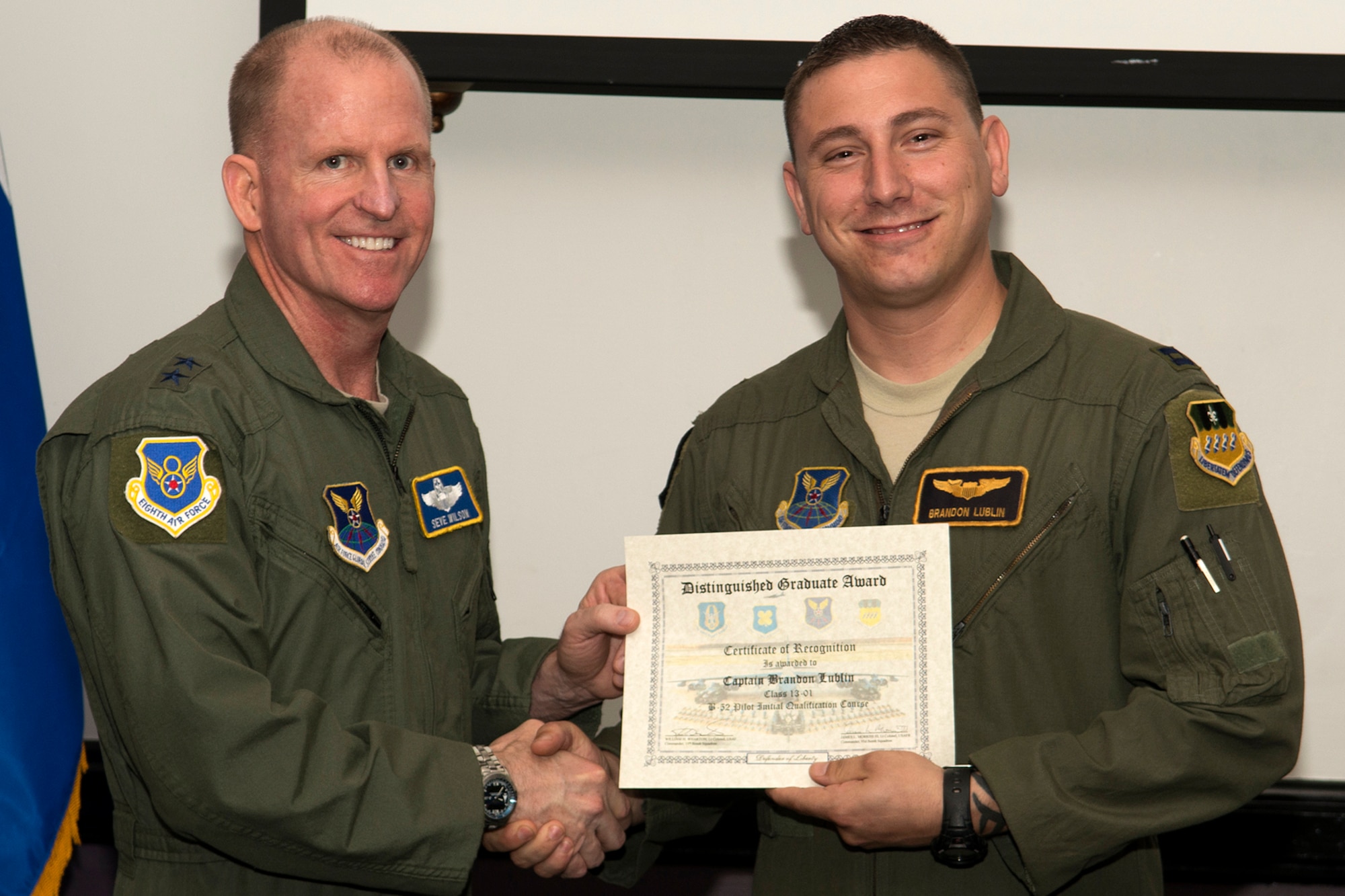 U.S. Air Force Maj. Gen. Stephen Wilson, Eighth Air Force commander, presents the Copilot Distinguished Graduate certificate to Capt. Brandon Lublin, during a Formal Training Unit graduation ceremony, June 14, 2013, Barksdale Air Force Base, La. The award is a culmination of academic tests, flight evaluations, officership, attitude and professional bearing that was consistently and clearly above their peers. (U.S. Air Force photo by Master Sgt. Greg Steele/Released)