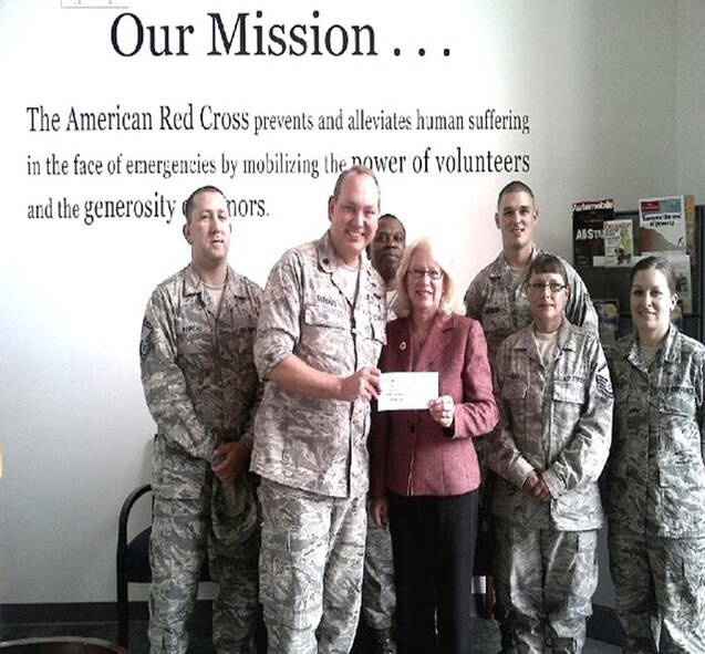 Lt. Col. Paul Stroud, 927th Aerospace Medicine Squadron deputy commander and some of the contributors pictured left to right:  Senior Master Sgt. Daniel Kupcho, Lt. Col. Paul Stroud, Senior Master Sgt. James Terry, Senior Airman David Wenger, Master Sgt. Dana Vogt, and Master Sgt. Angela Mitchell presented Janet McGuire, American Red Cross regional communications officer with a $700 dollar check for Oklahoma tornado relief. (Official U.S. Air Force photo/Courtesy 927th AMDS)  