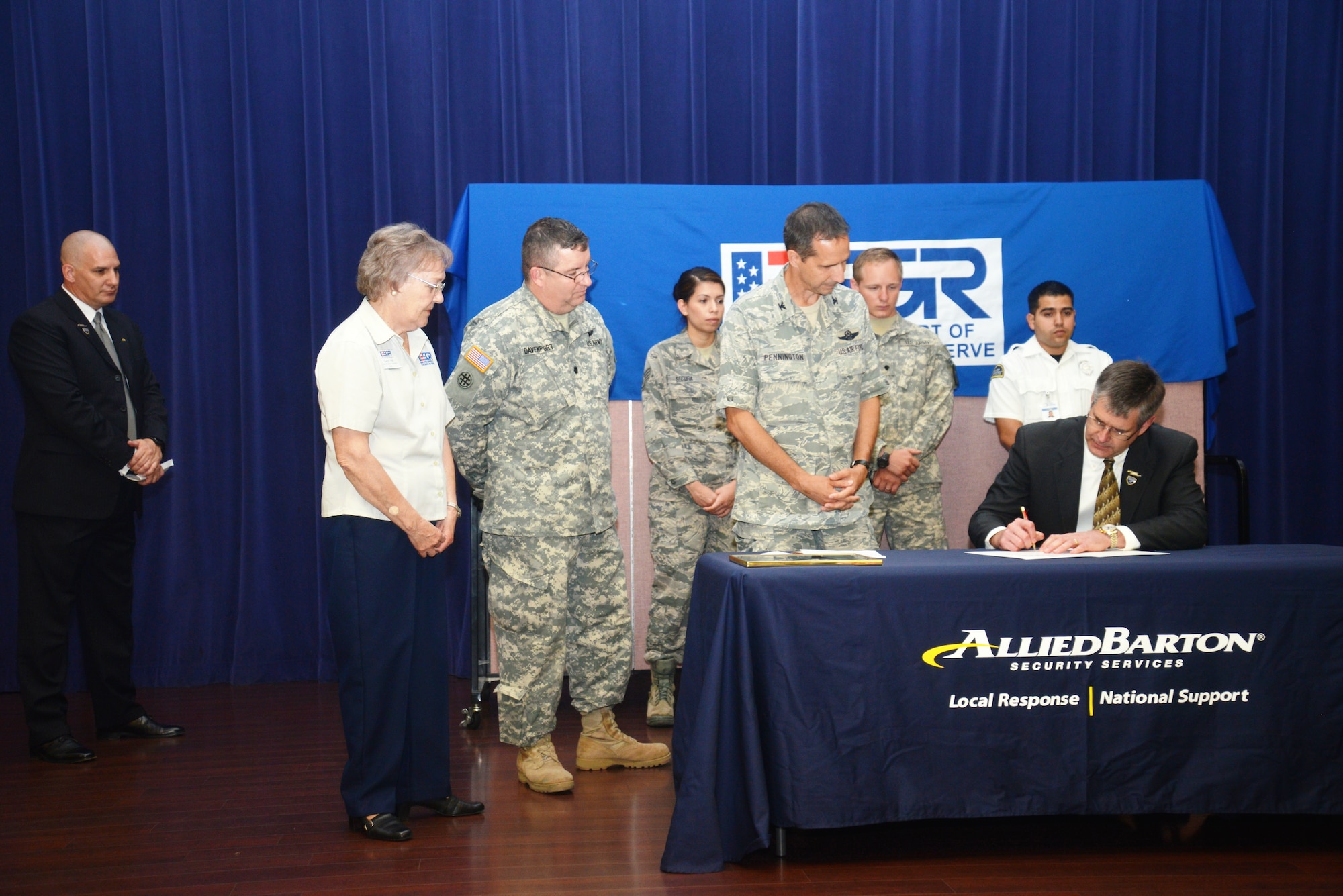 Col. Jeffrey Pennington, 433rd Airlift Wing, commander, Joint Base San Antonio-Lackland, look on as Michael Embree, Vice President of Operations, AlliedBarton Security Services signs an Employer Support of the Guard and Reserve program Statement of Support during an hiring event, June 25 at the Warfighter and Family Readiness center at Joint Base San Antonio-Fort Sam Houston. (U.S. Air Force Photo/SMSgt Minnie Jones)