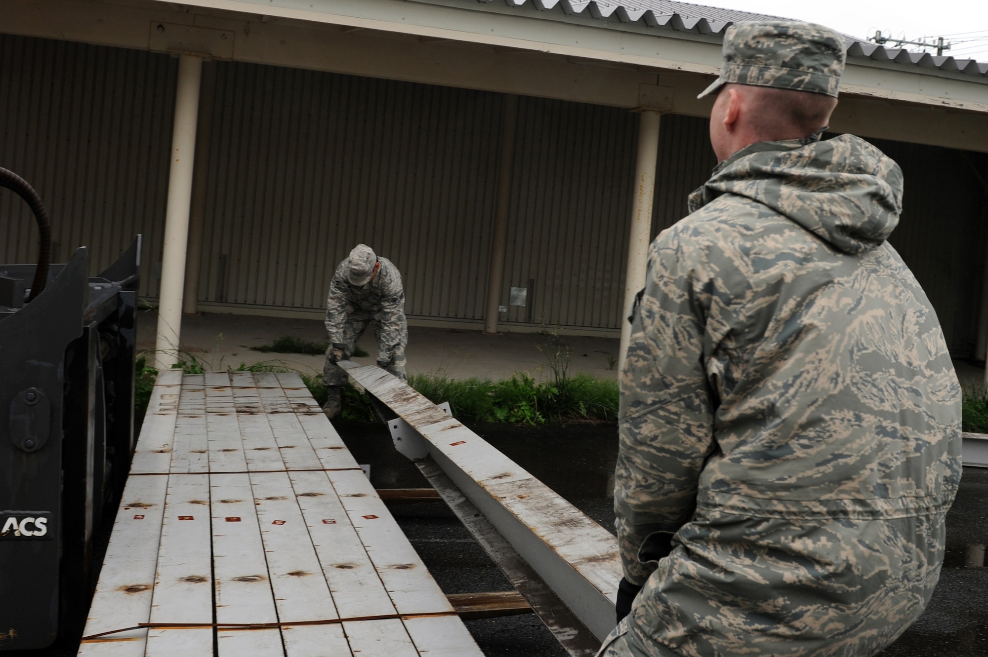U.S. Air Force Senior Airmen Travis Stout, right, and Nicholas Ellis, 35th Civil Engineer Squadron structural journeymen, move scrap metal onto a forklift at Misawa Air Base, Japan, June 27, 2013. The metal was scrap from a mezzanine project they had previously finished. The scrap metal is taken to Defense Logistics Agency Disposition Services where they decide if it can be re-used for another project. (U.S. Air Force photo by Airman 1st Class Kia Atkins)
