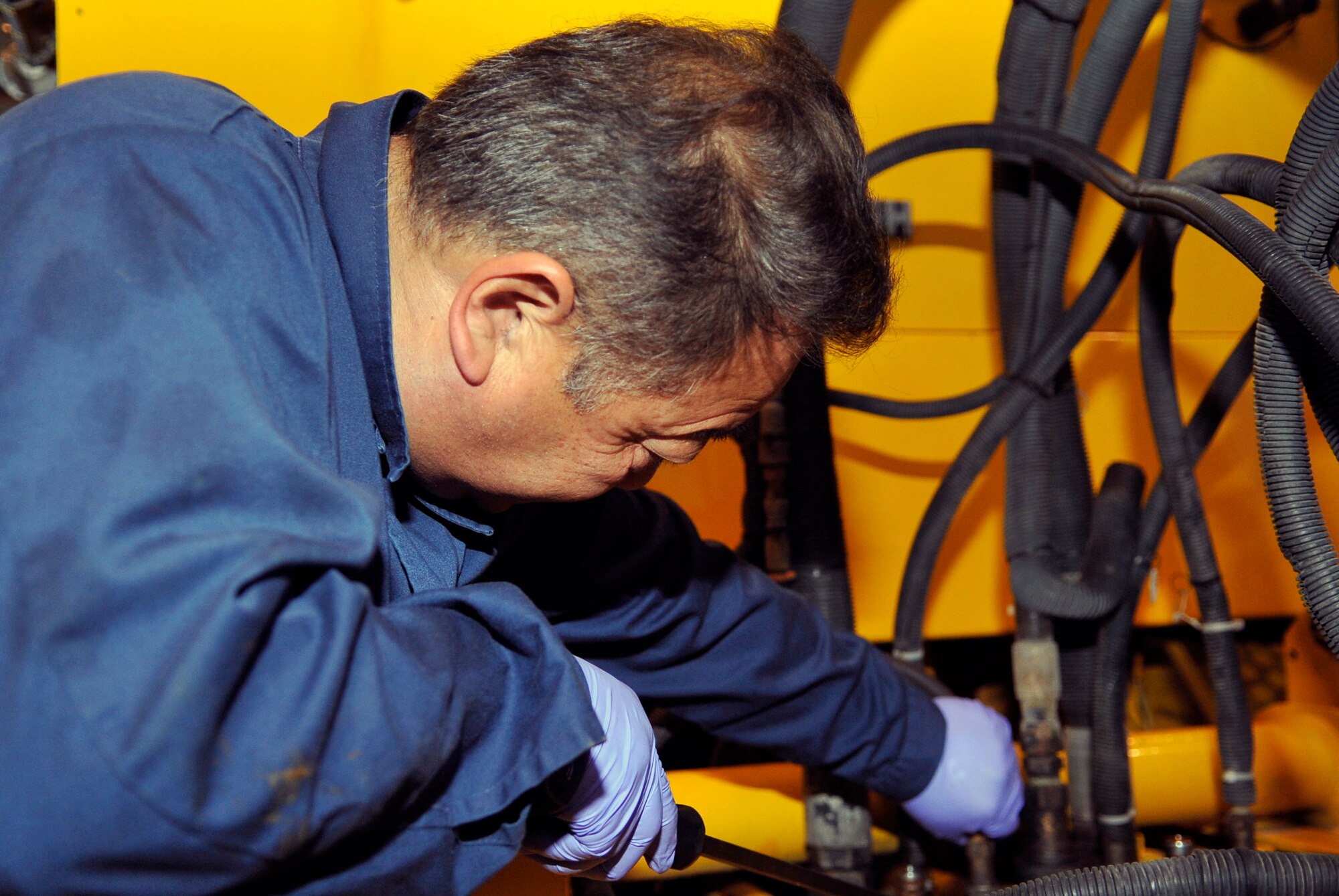Yoshinori Niwa, 35th Logistics Readiness Squadron vehicle maintenance technician, replaces a quick disconnect fitting on a snow broom at Misawa Air Base, Japan, June 27, 2013. The Vehicle Management Flight maintains more than 70 pieces of snow removal equipment on base. (U.S. Air Force photo by Airman 1st Class Zachary Kee)
