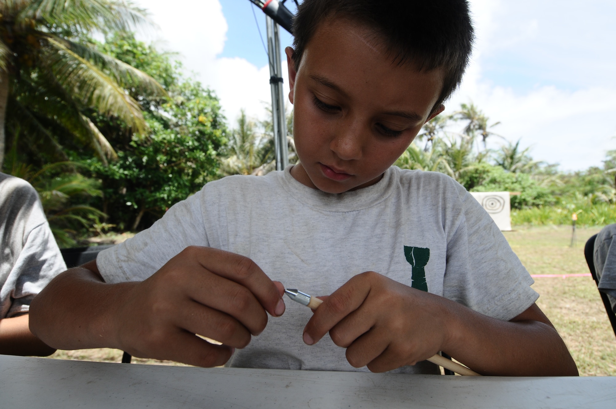 A scout works on an arrowhead during the annual Boy Scout Summer Camp in order to earn a merit badge, June 19, on Andersen Air Force Base, Guam. More than 400 merit badges were awarded at the camps conclusion and six Scouts completed final requirements that helped them achieve the rank of Eagle Scout. (U.S. Air Force photo by Airman 1st Class Mariah Haddenham/Released)
