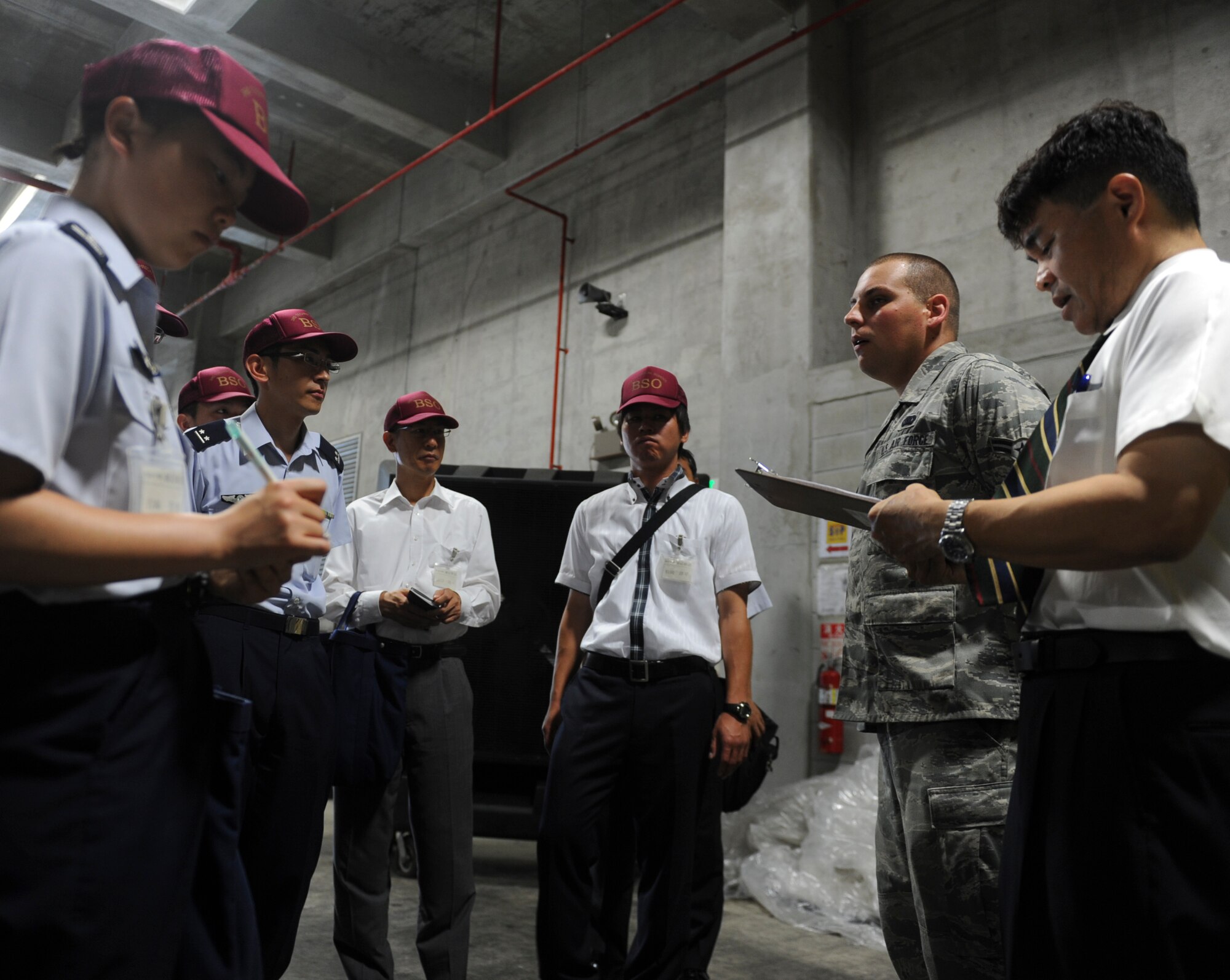U.S. Air Force Airman 1st Class Jack Coffman, 18th Logistics Readiness Squadron supply apprentice, briefs Japan Air Self-Defense Force service members on Kadena Air Base, Japan, June 26, 2013. Approximately 19 JASDF service members visited different facilities to get a better understanding of the 18th Wing’s mission, which enables the JASDF service members to use their new found knowledge to help better their mission. (U.S. Air Force photo by Airman 1st Class Justin Veazie/Released)