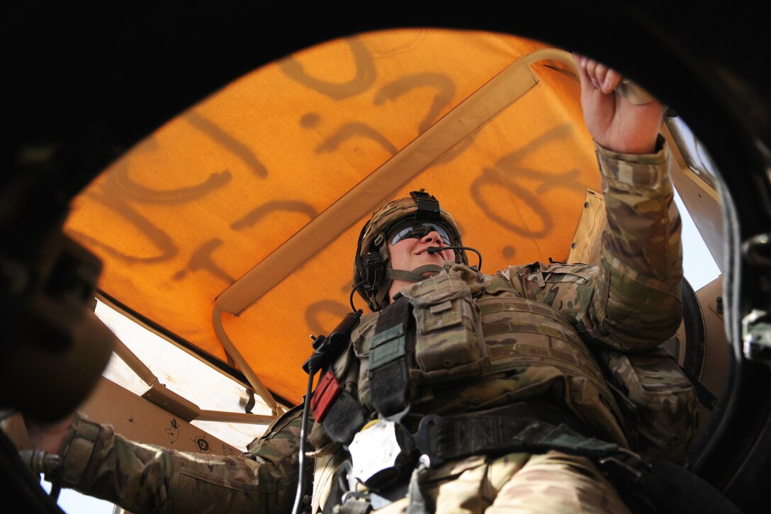 U.S. Army Spc. Luke Pierson mans the gunner's turret of a tactical vehicle before departing Forward Operating Base Farah for a meeting with the director of agriculture, irrigation and livestock in Farah City, Afghanistan, June 25, 2013. Pierson is assigned to Provincial Reconstruction Team Farah.