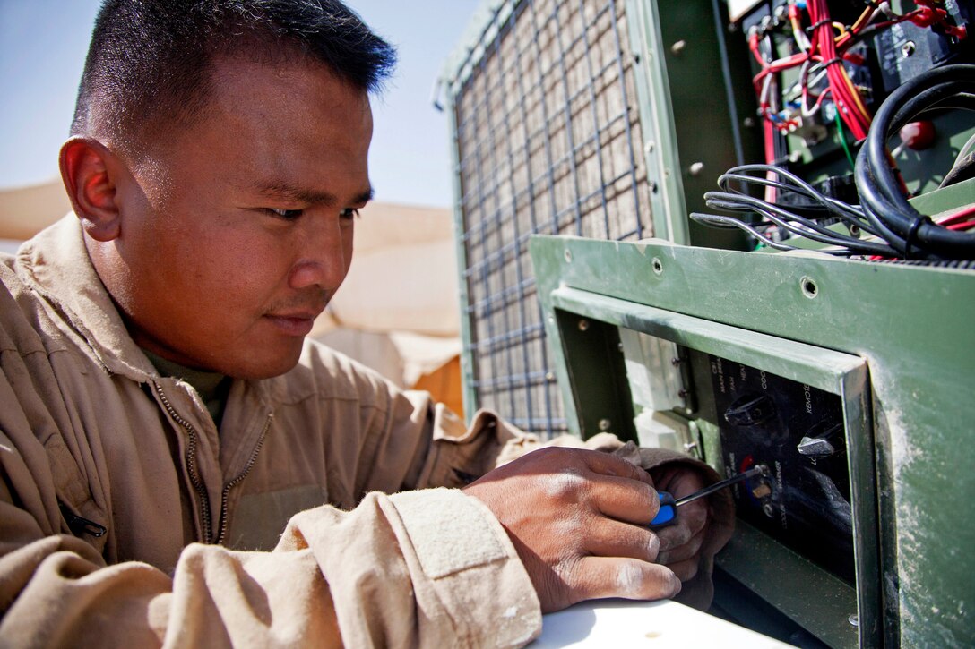 U.S. Marine Corps Cpl. Jared Panlasigui repairs a broken air