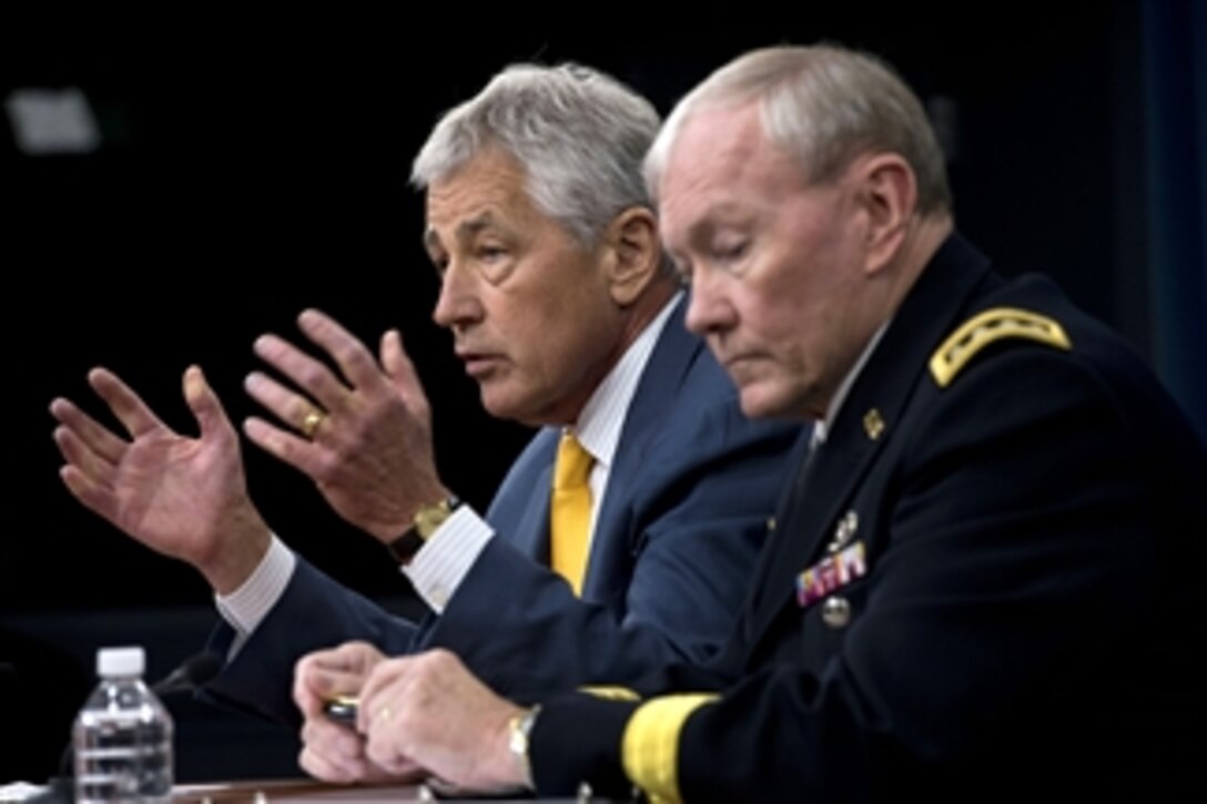 Secretary of Defense Chuck Hagel, left, answers a reporter’s question as he and Chairman of the Joint Chiefs of Staff Gen. Martin Dempsey brief the press at the Pentagon in Arlington, Va., on June 26, 2013.  Hagel announced that President Barack Obama has nominated Dempsey and Vice Chairman of the Joint Chiefs of Staff Adm. James Winnefeld Jr. to a second two-year term.   