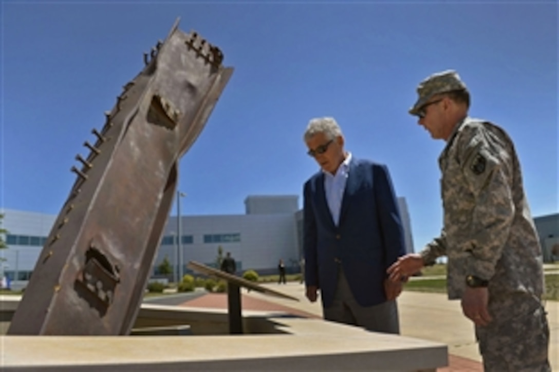 Defense Secretary Chuck Hagel, left, looks over a 9/11 monument made from a remnant of the World Trade Center with Army Gen. Charles H. Jacoby Jr., commander of U.S. Northern Command, outside Northcom headquarters on Peterson Air Force Base, Colorado Springs, Colo., June 27, 2013. Hagel also plans to visit the North American Aerospace Defense Command and meet with leaders to discuss issues such as homeland defense, integrated air and missile defense, U.S. - Mexico military-to-military relations.