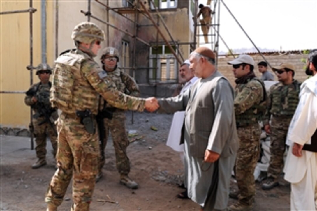 U.S. Navy Lt. j.g Matthew Harvie, left, greets Farah prosecutors outside the courthouse before a meeting with the Farah chief justice in Farah City, Afghanistan, June 25, 2013. Harvie is assigned to Provincial Reconstruction Team Farah. 