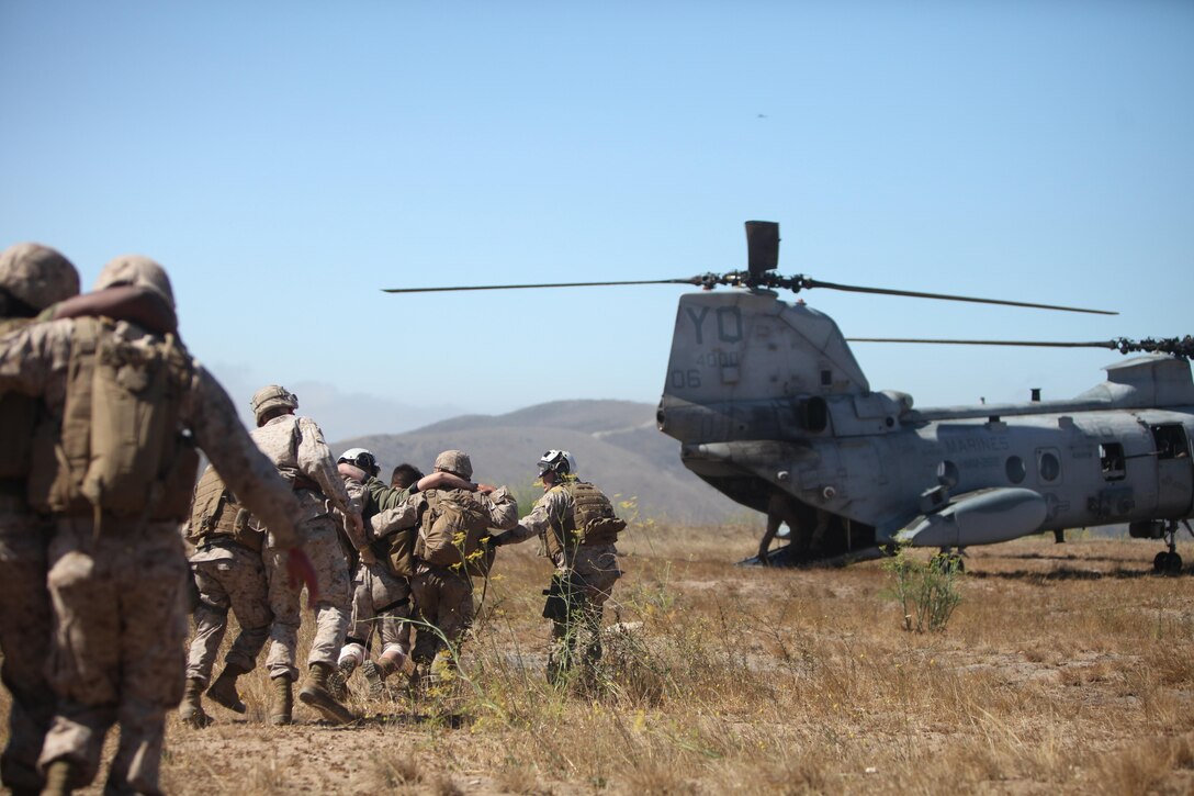 Marines from 2nd Battalion, 5th Marine Regiment, 1st Marine Division, and Marine Medium Helicopter Squadron 268, 3rd Marine Aircraft Wing, extract simulated casualties played by sailors from 1st Medical Battalion, 1st Marine Logistics Group, during a mass casualty exercise aboard Camp Pendleton, Calif., June 26, 2013. The exercise was conducted in support of Dawn Blitz 2013. 