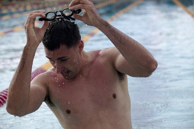 Dezmond Oyandadel, a swimmer from Combat Logistics Battalion 3, and 24-year-old native of Wolocott, Conn., takes his goggles off after a 50-meter race during the 101 Days of Summer Swim Meet at the base pool, June 21, 2013. (U.S. Marine Corps photo by Lance Cpl. Janelle Y. Chapman) 