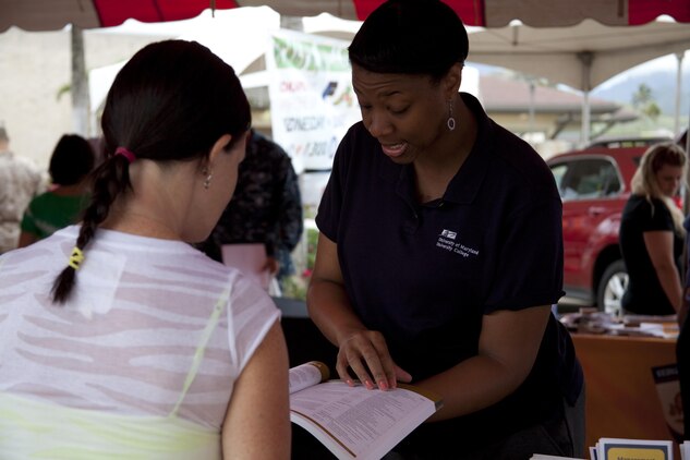 Marine spouse Tabitha Fox (left) gets information about education by a University of Maryland promoter at the Health, Wellness and Fitness Fair at Mokapu Mall, June 26, 2013. (U.S. Marine Corps photo by Lance Cpl. Janelle Y. Chapman)