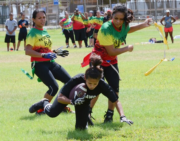 Wahine Koa players Tefany Gonzales (left) and Tiare Lyles (right) stop Wardawgz running back Tiffany Epps by taking her flag during a Hawaii Gridiron League flag football game at Kapiolani Park, June 23, 2013. (U.S. Marine Corps photo by Kristen Wong)