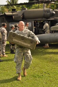U.S. Army Maj. Stephen Poe, Medical readiness training exercise officer-in-charge, carries medical supplies from a Utility Helicopter-60 during a MEDRETE held in the remote region of Bara Patuca, Gracias a Dios, June 25-26, 2013. JTF-Bravo conducts MEDRETEs throughout Central America each year in support of U.S. Southern Command's humanitarian assistance and disaster relief programs in order to strengthen civil-military cooperation between the United States and nations in the region. In coordination with the Offices of Security Cooperation and partner nation Department of Health Officials in all seven Central American countries, JTF- Bravo treated more than 11,000 patients, last year.