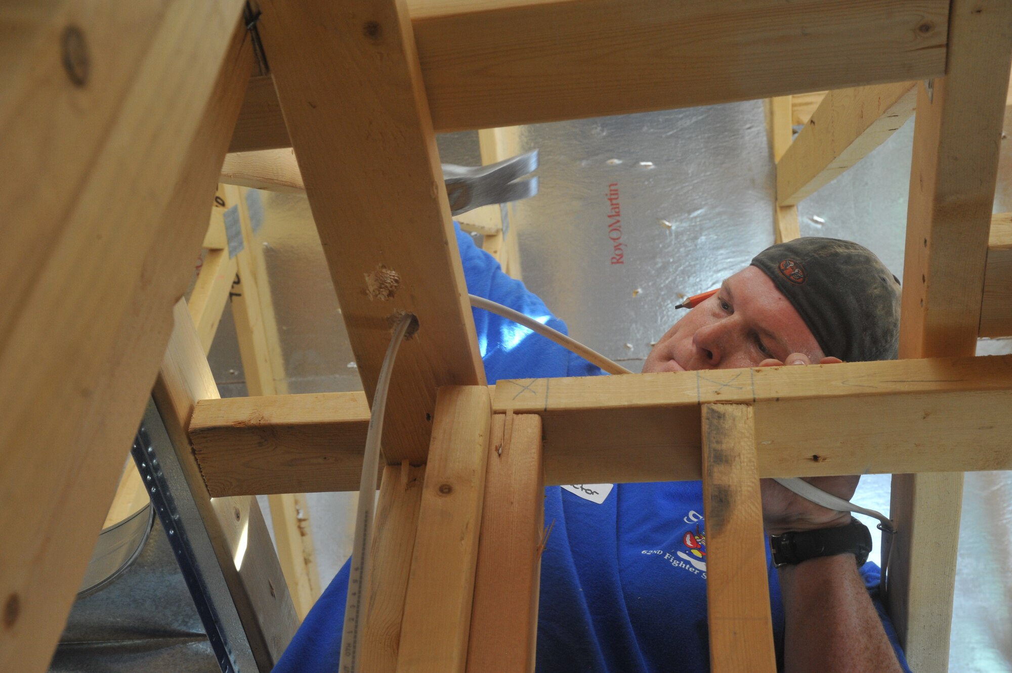 Maj. Andrew Stockman, 62nd FS assistant director of operations, hammers down a nail to secure an air vent. HFH exists because, there is a critical need for affordable housing for low-income families.