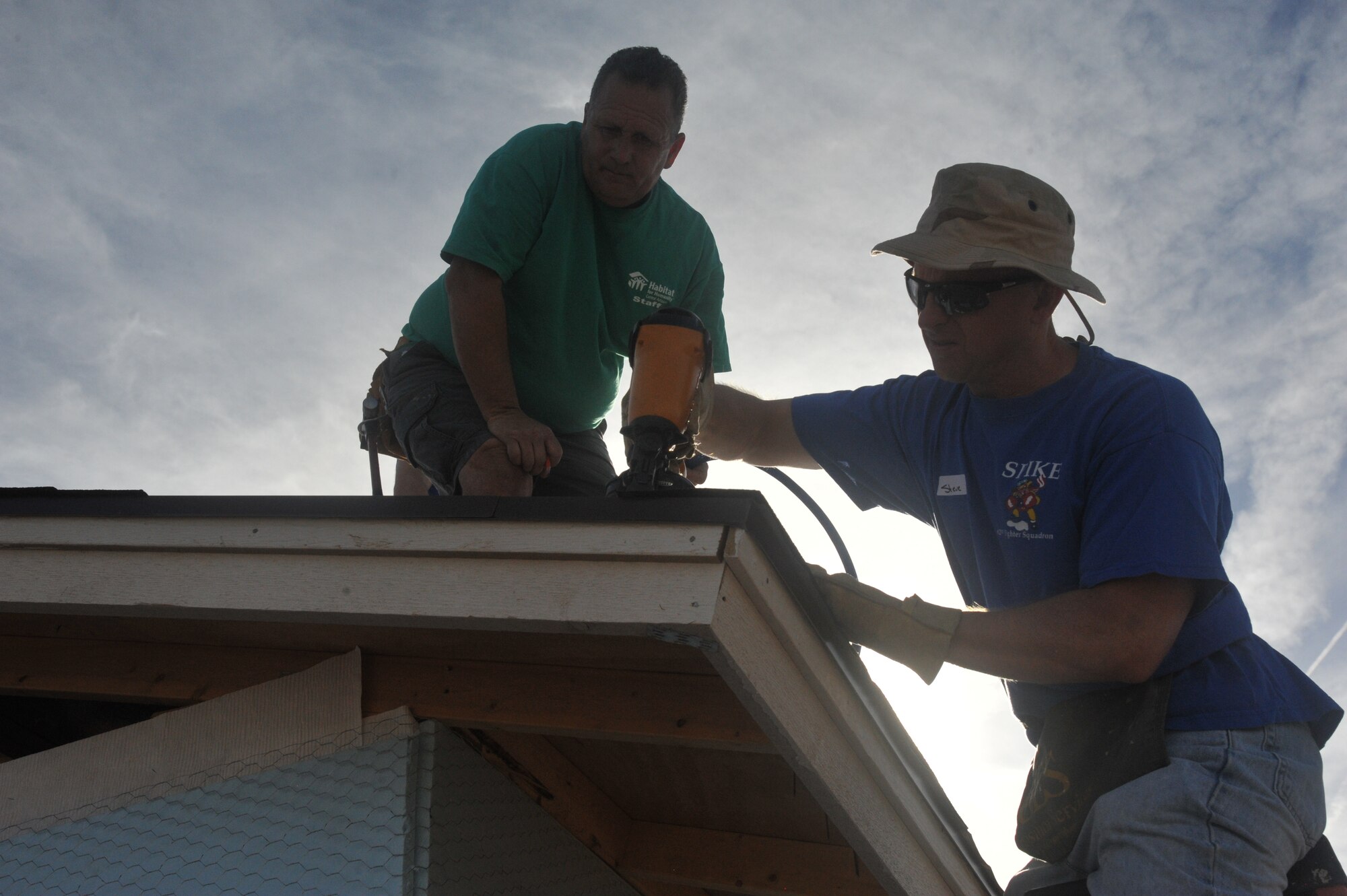 Maj. Travis Swan, 62nd FS chief of scheduling, nails shingles on the edge of a roof during the project. Habitat for Humanity Central Arizona has built, renovated and repaired more than 825 homes throughout Maricopa County.