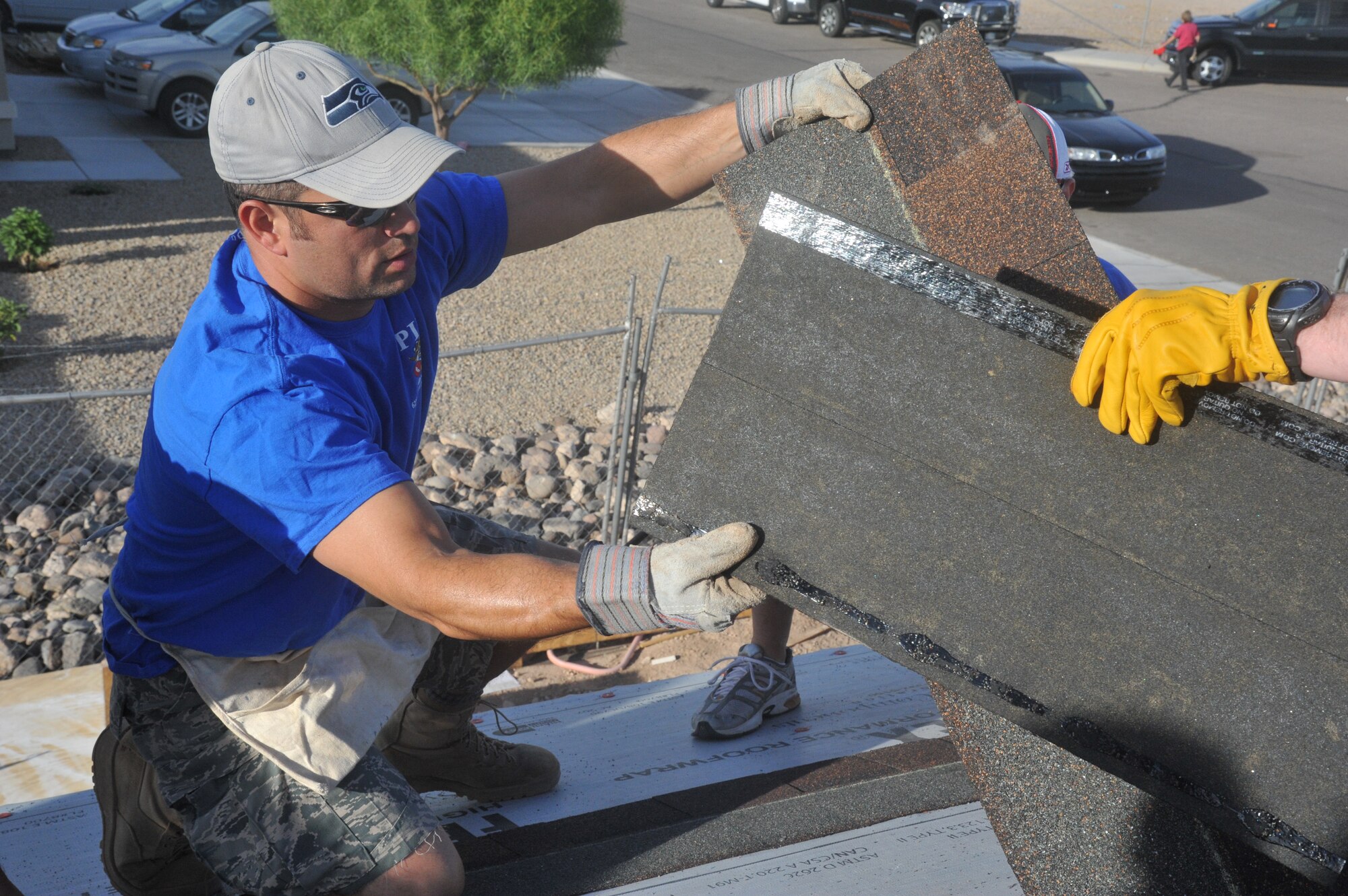 Capt. Nick Rallo, 62nd FS C flight commander, is handed shingles Saturday as part of the Habitat for Humanity volunteer opportunity in Avondale. HFH is an international, nonprofit agency that builds and repairs houses all over the world using volunteer labor and donations.