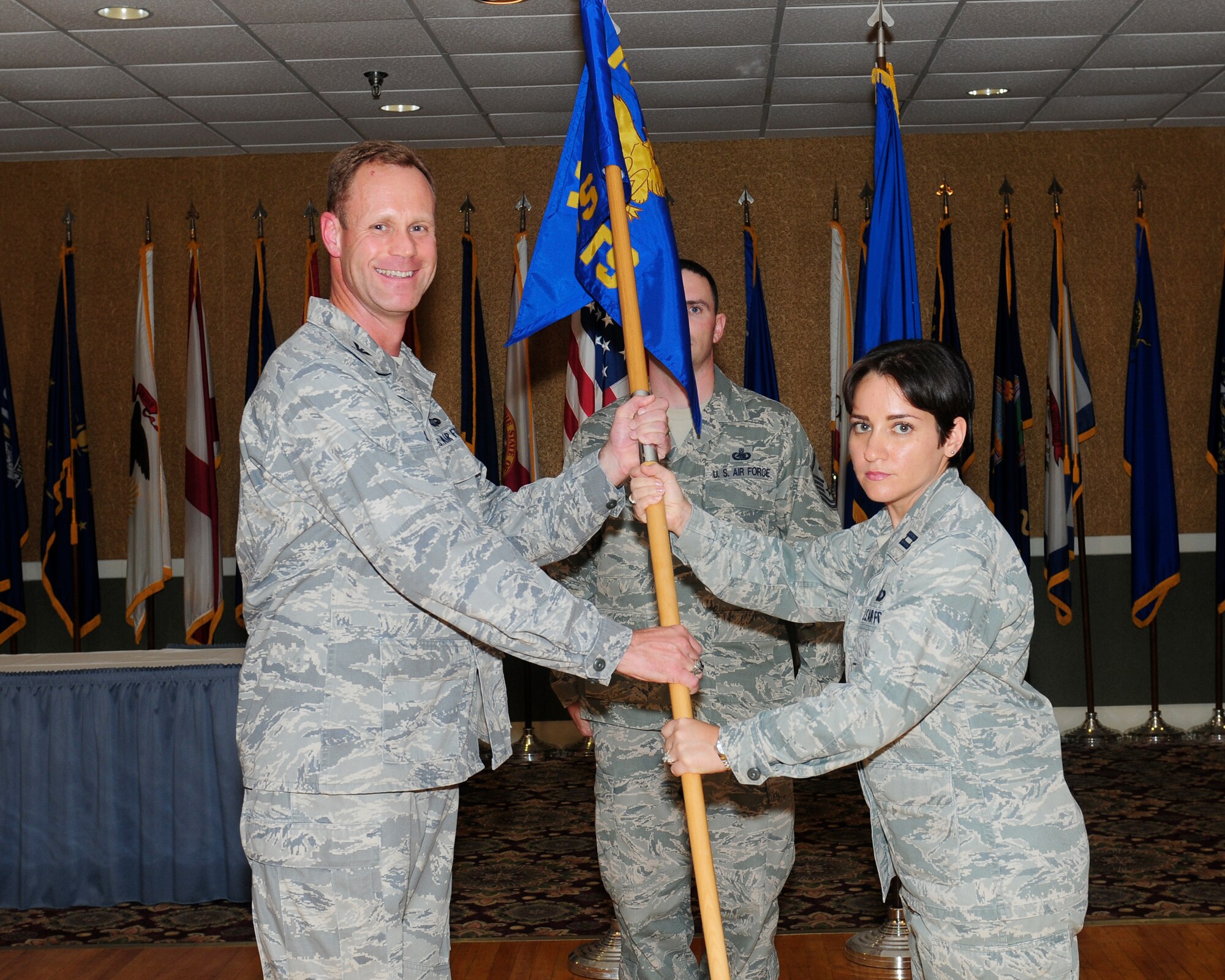 Col. Jim Sears, 14th Flying Training Wing commander, hands the guidon to Capt. Leria Diaz, incoming 14th Comptroller Squadron commander, at a change-of-command ceremony June 20 at the Columbus Club.  Diaz comes to Columbus from Randolph AFB, Texas where she was the Command Financial Analyst.  (U.S. Air Force Photo/Melissa Duncan)