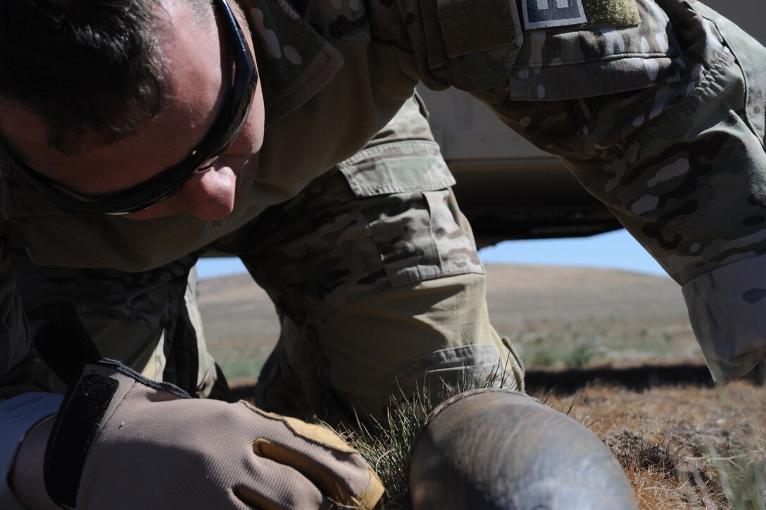 Tech. Sgt. Taylor Saum, 366th Civil Engineer Squadron explosive ordnance disposal noncommissioned officer-in-charge of logistics, examines a munition he discovered June 5, 2013, at Mountain Home Air Force Base, Idaho.  Many of the bombs found are simply marked with flags for Airmen to return at a later date and detonate.  (U.S. Air Force photo by Senior Airman Benjamin Sutton/Released)