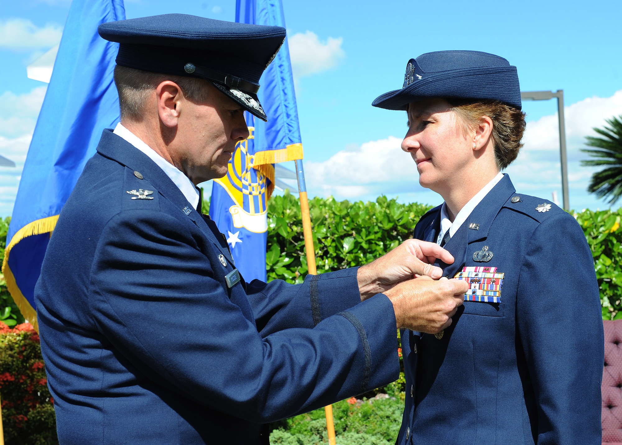 Col. Johnny Roscoe, 15th Wing commander, pins a meritorious service medal on Lt. Col. Theresa Sheppard, former 15th Comptroller Squadron commander, prior to her change of command ceremony held at the Missing Man Formation on Joint Base Pearl Harbor-Hickam, Hawaii, June 27, 2013. The meritorious service medal is awarded to members of the United States Armed Forces who distinguished themselves by outstanding meritorious achievement or service to the United States. (U.S. Air Force photo/Tech. Sgt. Jerome S. Tayborn)