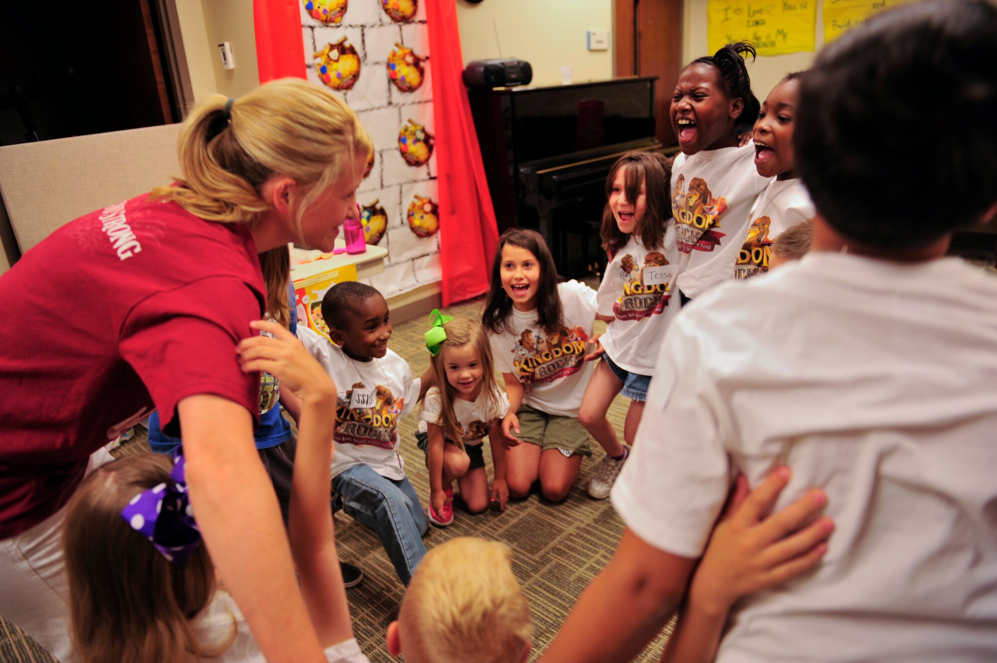 Amanda Vineyard, Vacation Bible School volunteer and wife of Capt. Jared Vineyard, 743rd Military Intelligence Battalion chaplain, huddles with a group of children while teaching during VBS week June 26, 2013, at the chapel on Buckley Air Force Base, Colo. The VBS curriculum included several types of learning styles such as singing, dancing, acting, and arts and crafts. (U.S. Air Force photo by Airman 1st Class Darryl Bolden Jr./Released)