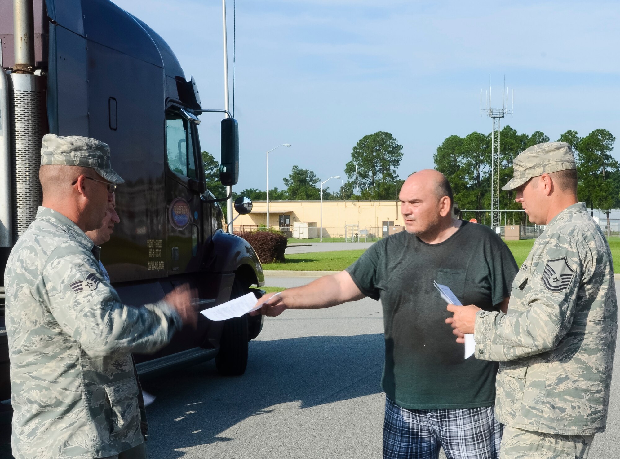 Senior Airman Dennis Tippens, left, and Master Sgt. Joel Furlough, 116th Civil Engineer Squadron, Georgia Air National Guard, take possession of two route clearance kits from a truck driver at Robins Air Force Base, Ga., June 27, 2013.  The civil engineering arm of the 116th Air Control Wing will use the kits, consisting of multi-purpose Kubota tractors, when called upon to quickly respond to disasters in their region.  The equipment gives the unit the capability to clear debris in the area of a disaster so emergency operations personnel can respond. (U.S. Air National Guard photo by Capt. Pamela Stauffer/Released)