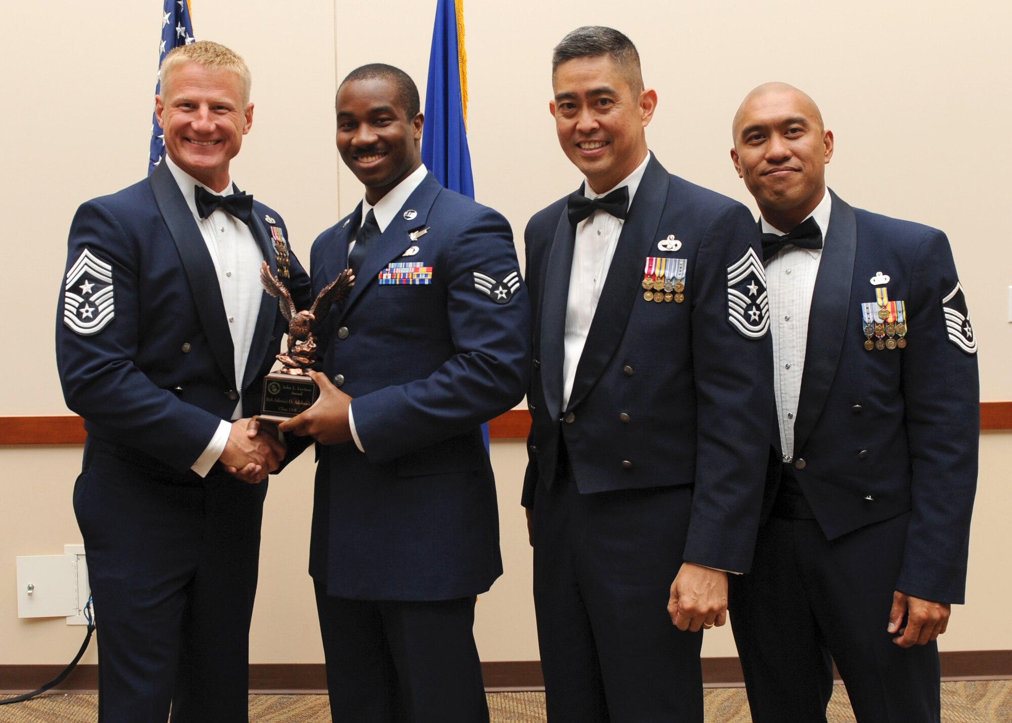 Senior Airman Adeniyi Adekunle, 566th Intelligence Squadron, receives the John L. Levitow Award, during the graduation of Buckley Airman Leadership School Class 13E June 27, 2013, at Buckley Air Force Base, Colo. The highest award presented, it is the pinnacle of success in ALS. The Levitow Award is presented to the student who demonstrated the most outstanding leadership and scholastic qualities. (U.S. Air Force photo by Senior Airman Marcy Glass/Released)