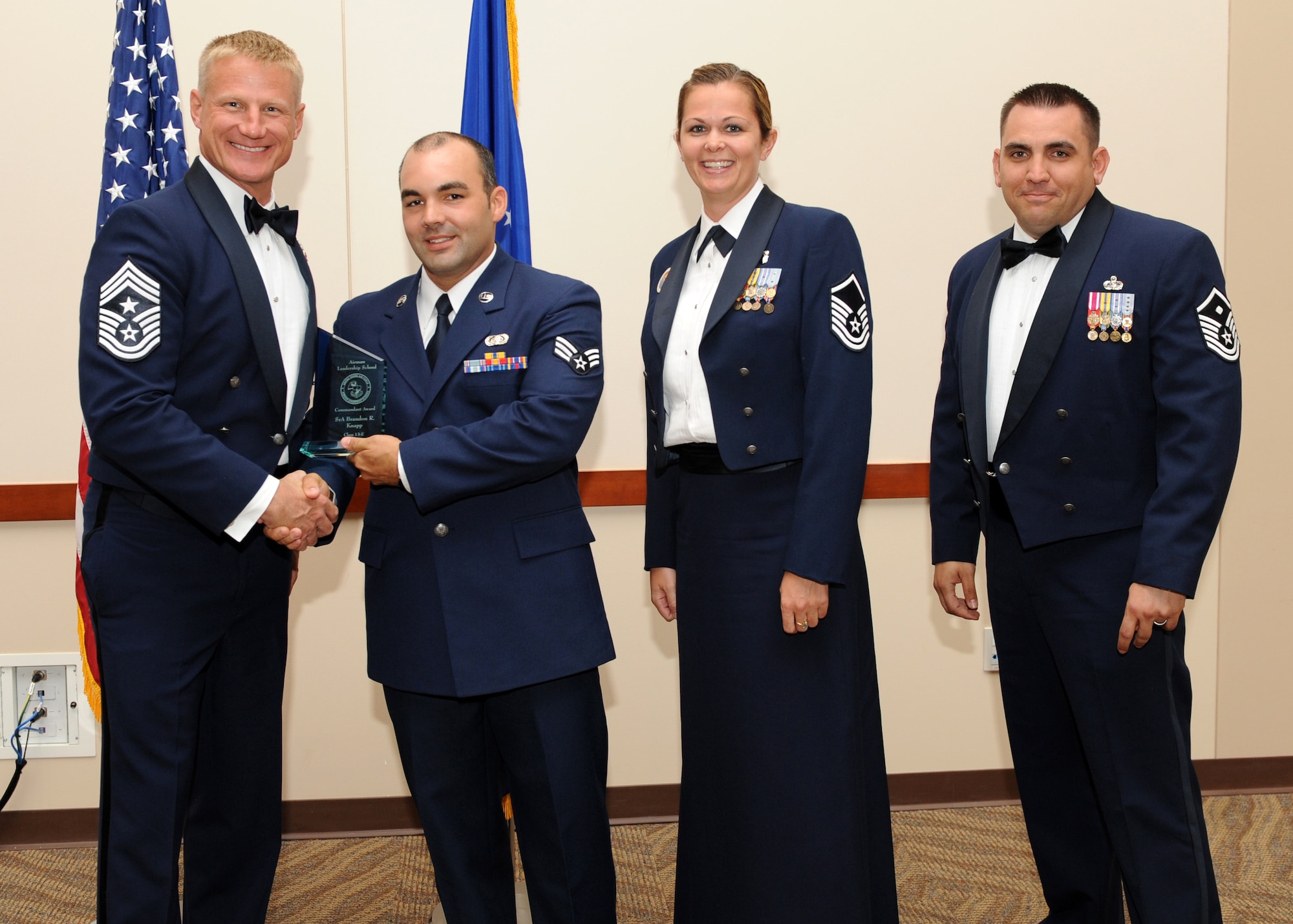 Senior Airman Brandon Knapp, 460th Space Communications Squadron, receives the commandant award, during the graduation of Buckley Airman Leadership School Class 13E June 27, 2013, at Buckley Air Force Base, Colo. It is presented to the student who displayed all the characteristics of an effective leader during ALS. (U.S. Air Force photo by Senior Airman Marcy Glass/Released)