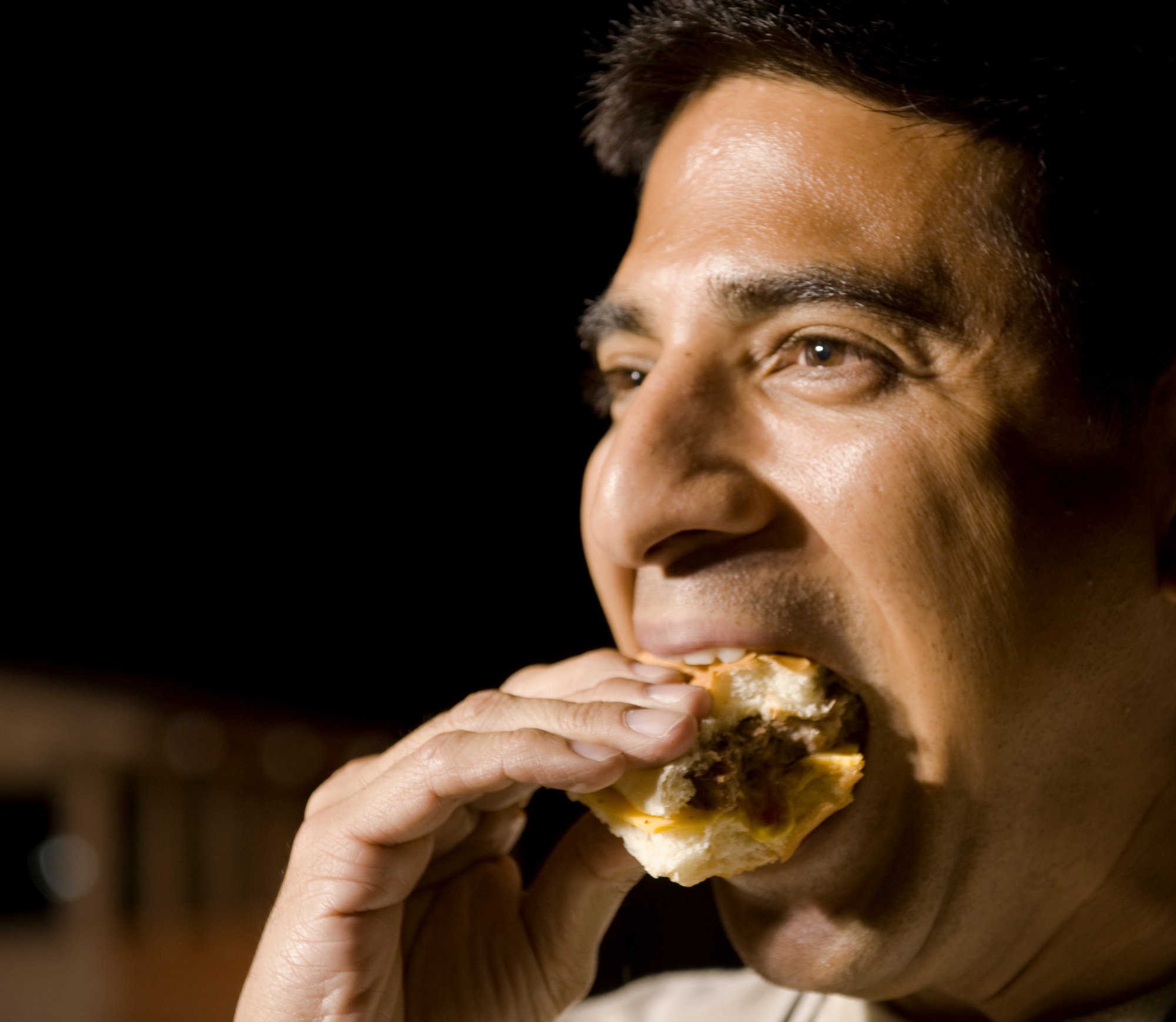 U.S. Air Force Tech. Sgt. Dave Gallon, 7th Aircraft Maintenance Squadron, eats a hamburger June 26, 2013, at Dyess Air Force Base, Texas. First sergeants grilled hamburgers and hotdogs for the large number of night shift Airmen who attended the late night burger burn.  (U.S. Air Force photo by Airman 1st Class Peter Thompson/Released)