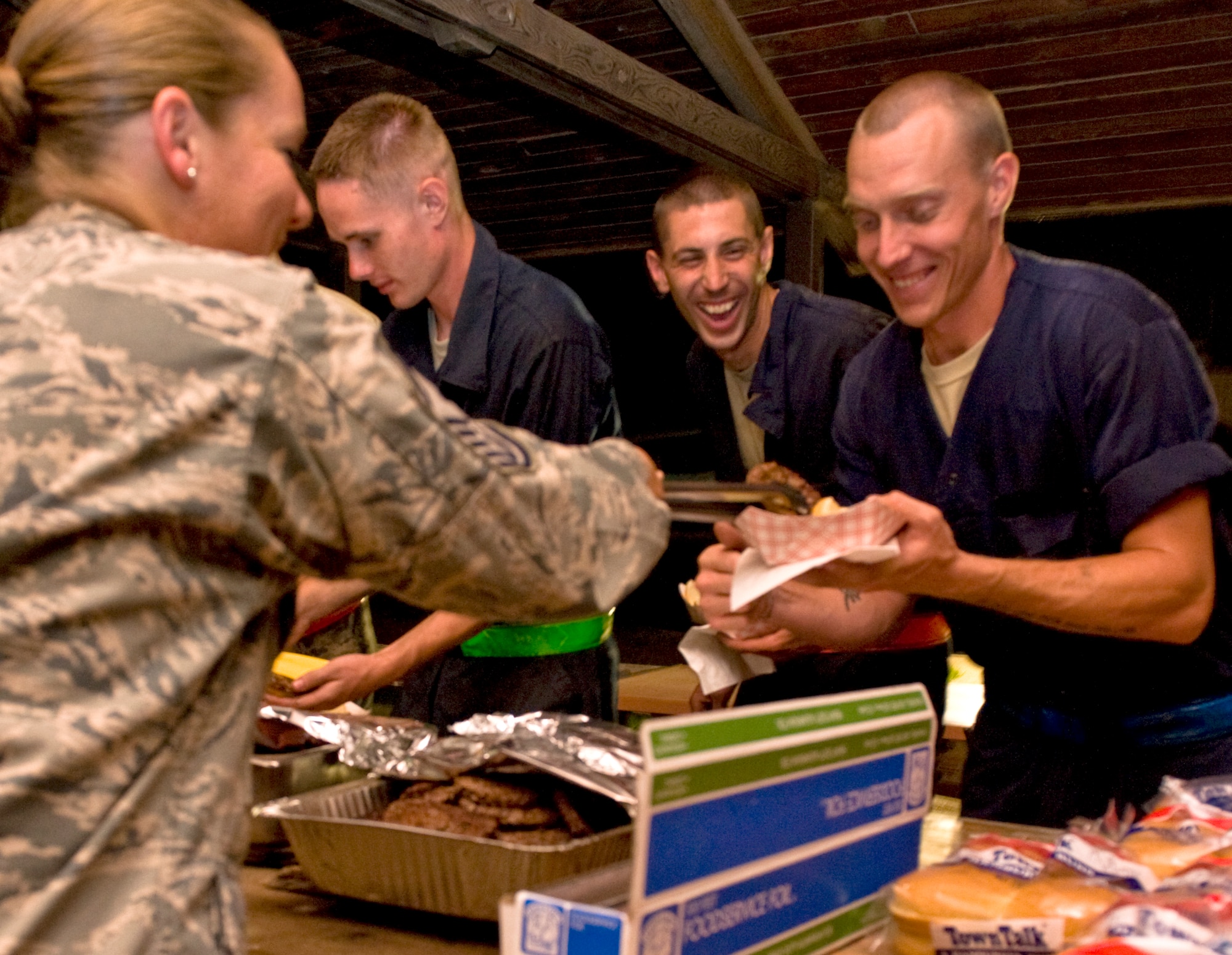 Airmen from the 7th Aircraft Maintenance Squadron are served hamburgers and hotdogs by their first sergeant, Senior Master Sgt. Christy Hayes, June 26, 2013, at Dyess Air Force Base, Texas. Night shift Airmen were treated to grilled food, refreshments and an opportunity to interact with many of the base’s first sergeants at the burger burn.  (U.S. Air Force photo by Airman 1st Class Peter Thompson/Released)