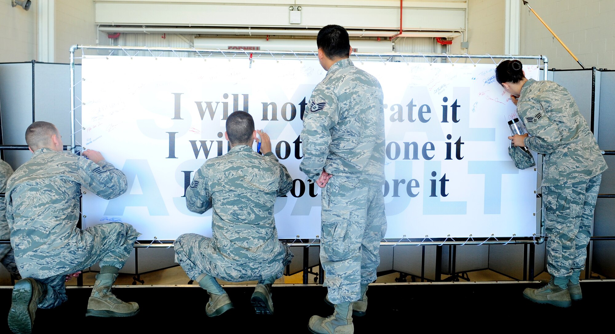 Beale Airmen sign a banner pledging to stop sexual assault during a sexual assault prevention and response brief at Beale Air Force Base, Calif., June 26, 2013. All of Team Beale was given an opportunity to sign the pledge. (U.S. Air Force photo by Airman 1st Class Bobby Cummings/Released)