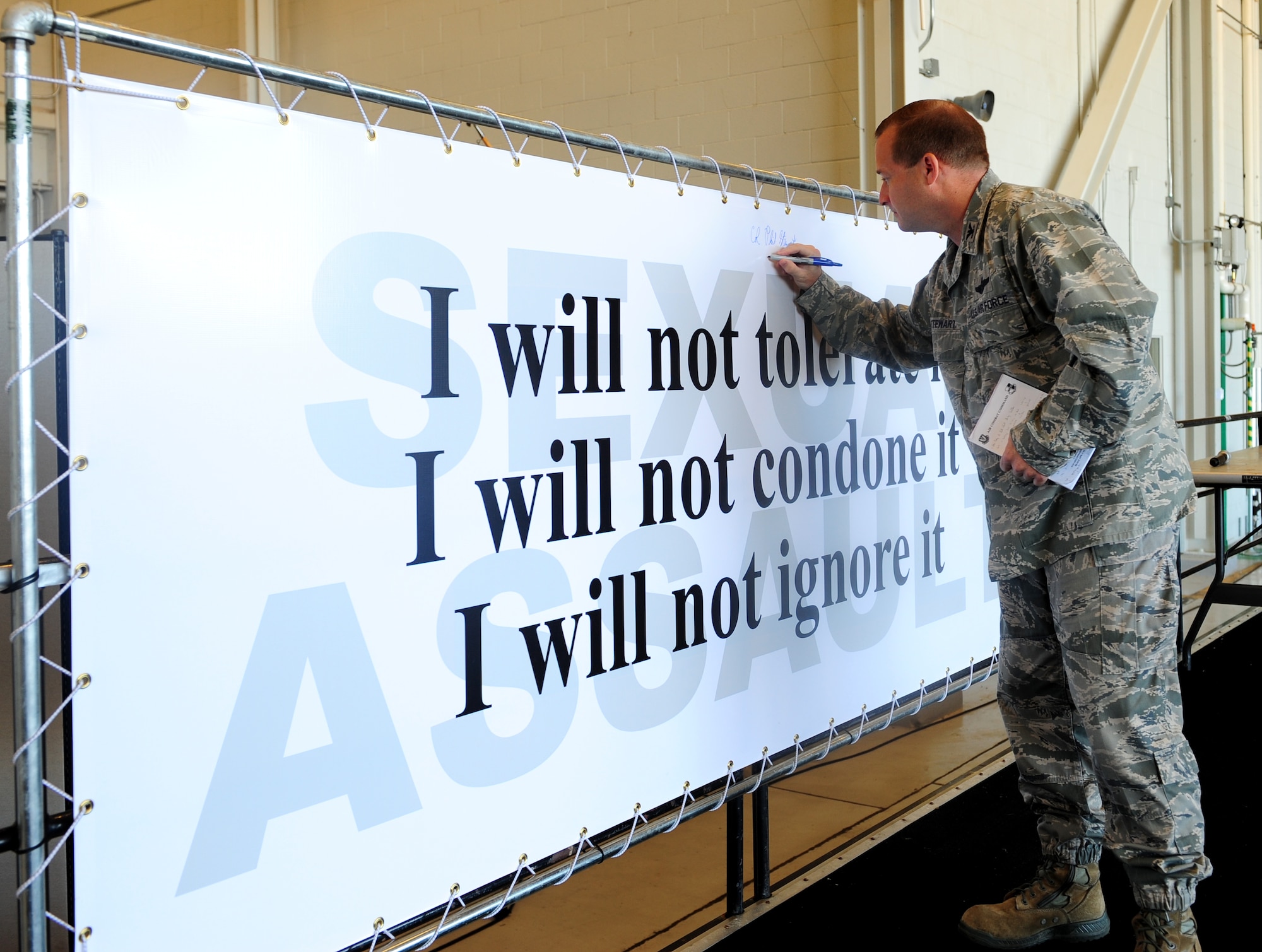 Col. Phil Stewart, 9th Reconnaissance Wing commander, signs a banner pledging to stop sexual assault during a sexual assault prevention and response brief at Beale Air Force Base, Calif., June 26, 2013. All of Team Beale was given the opportunity to sign the pledge. (U.S. Air Force photo by Airman 1st Class Bobby Cummings/Released)