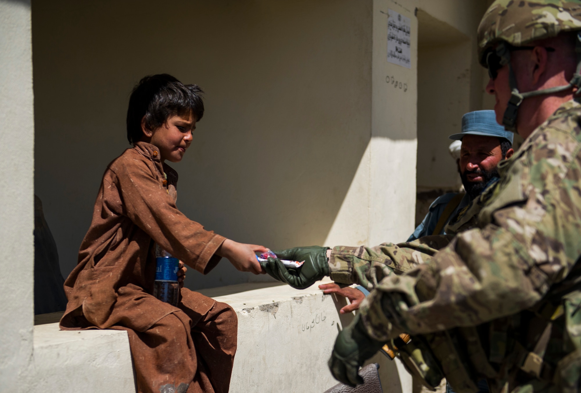Tech. Sgt. Michael Herrell shares candy with a local Afghan child during a mission, April 17, 2013, in Panjwai, Afghanistan. Herrell, a Kentucky Air National Guard finance specialist, is deployed as a Joint Expeditionary Tasked Airman with the 466th Air Expeditionary Squadron and is working as a Kentucky National Guard Agribusiness Development Team Agriculture team specialist. (U.S. Air Force photo/Staff Sgt. Marleah Miller)