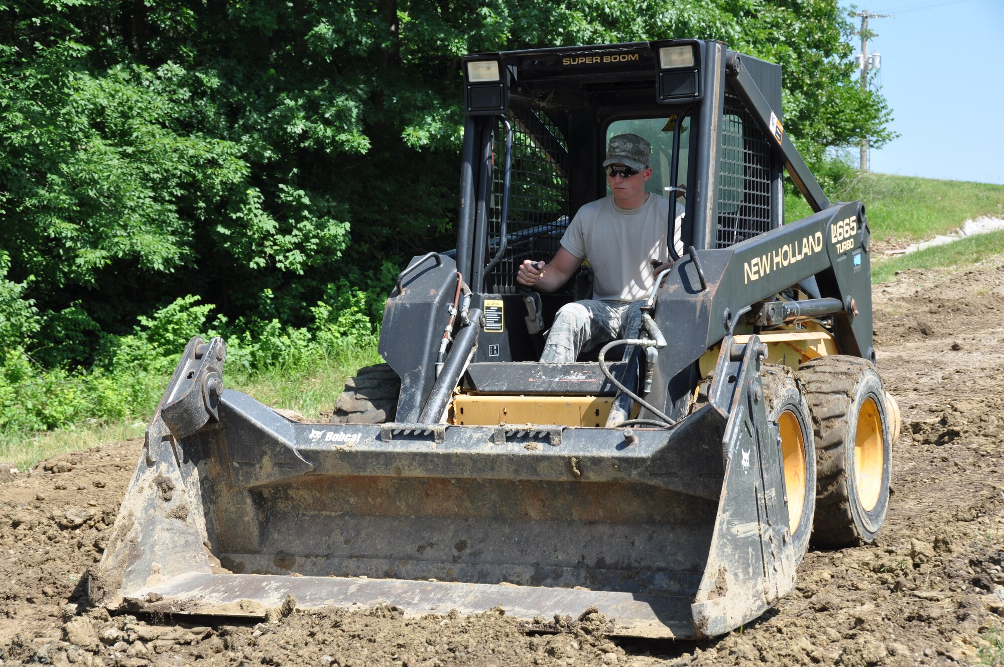 Senior Airman Kody Duggan, 442nd Civil Engineer Squadron water and fuel systems maintenance technician, smoothes a dirt road after helping to install a water pipe June 18, 2013. Members of the 442nd CES partnered with their active-duty counterparts to obtain the piping, which will ensure the 509th’s water needs there will be met. The 442nd CES is part of the 442nd Fighter Wing, an A-10 Thunderbolt II Air Force Reserve unit at Whiteman Air Force Base, Mo. (U.S. Air Force photo by Senior Airman Wesley Wright/Released)