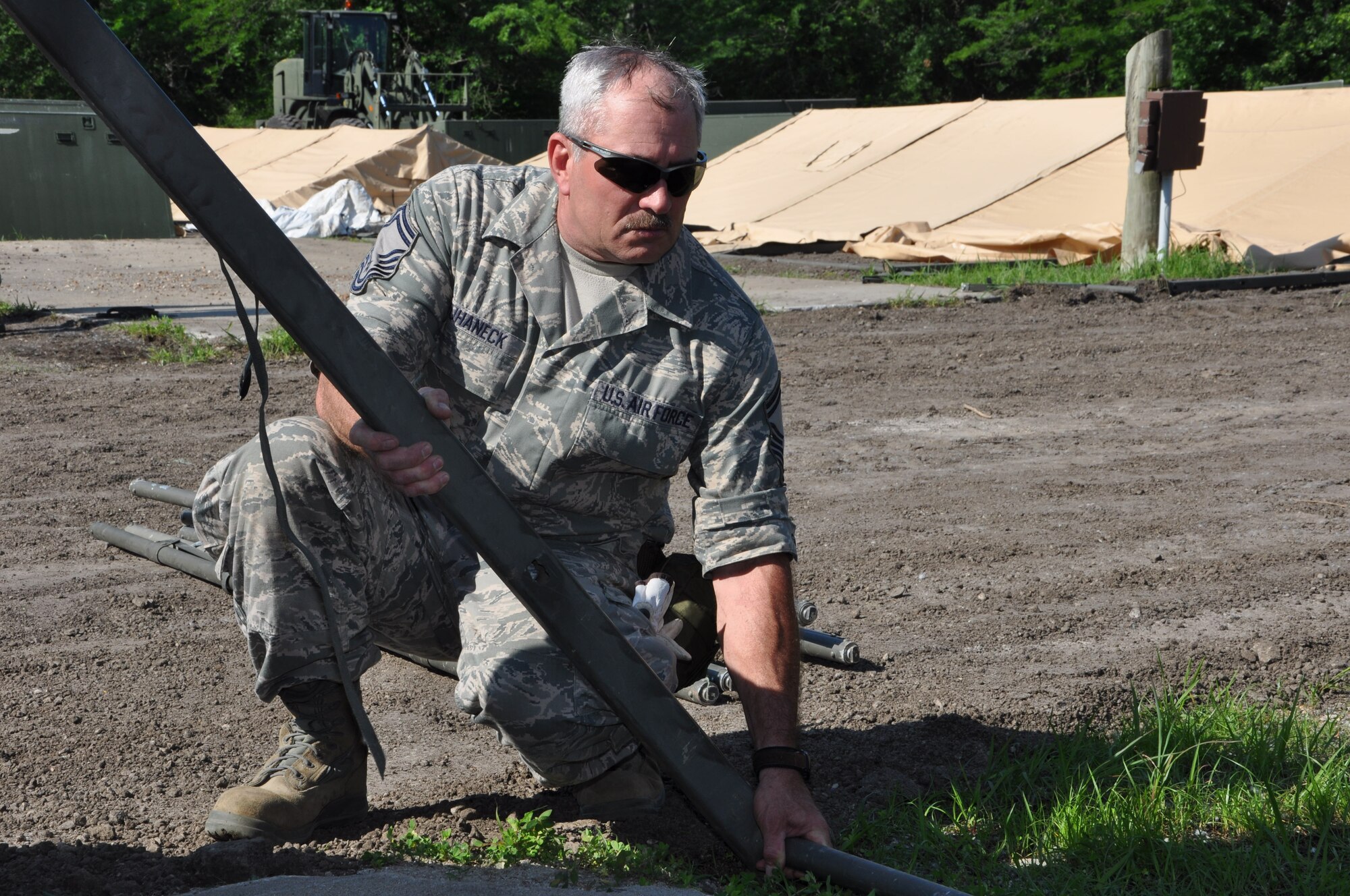 Senior Master Sgt. Mark Kuhaneck, 442nd Civil Engineer Squadron supervisor, helps stabilize a leg of a temper tent during CES field training, June 20, 2013. During the field training, members of 442nd CES set up and inventoried tents, prepared and manned defensive fighting positions. The 442nd CES is part of the 442nd Fighter Wing, an A-10 Thunderbolt II Air Force Reserve unit at Whiteman Air Force Base, Mo. (U.S. Air Force photo by Senior Airman Wesley Wright/ Released)